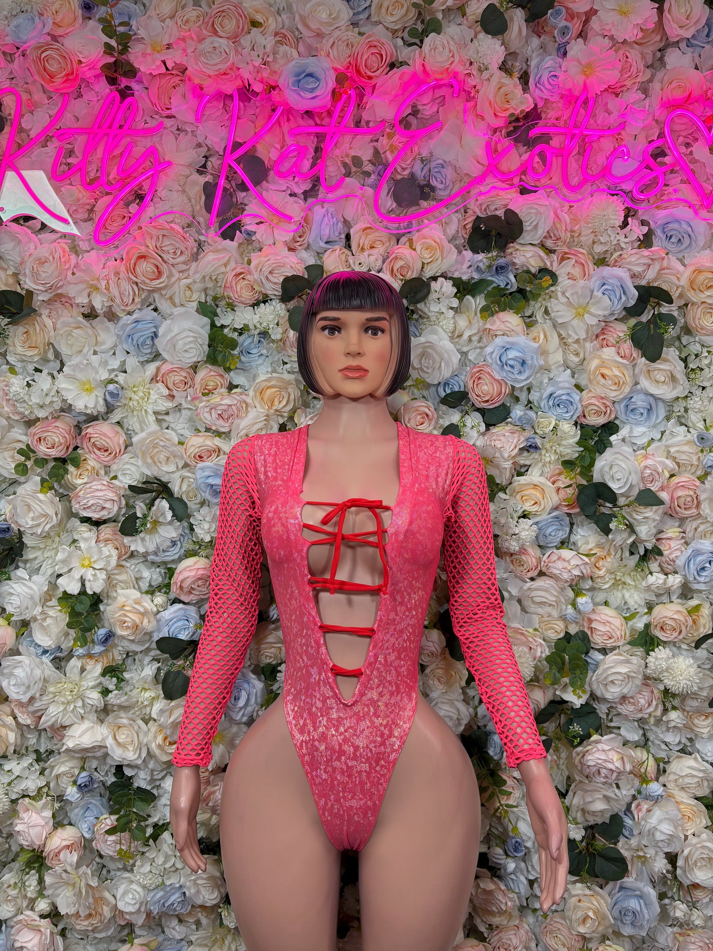 Pink metallic crushed bodysuit with long sleeves and lace-up front cutouts