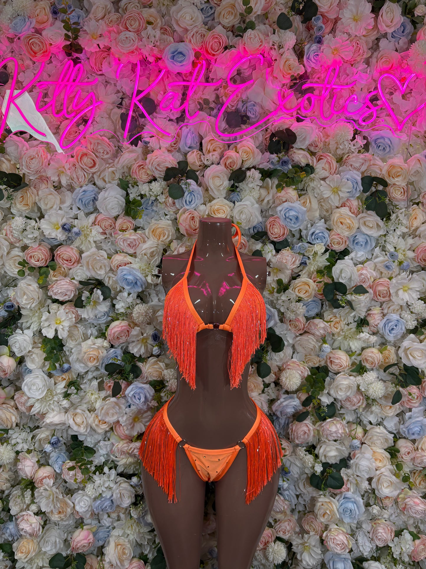 Orange fringe two-piece festival bikini set on mannequin, halter top and matching bottoms
