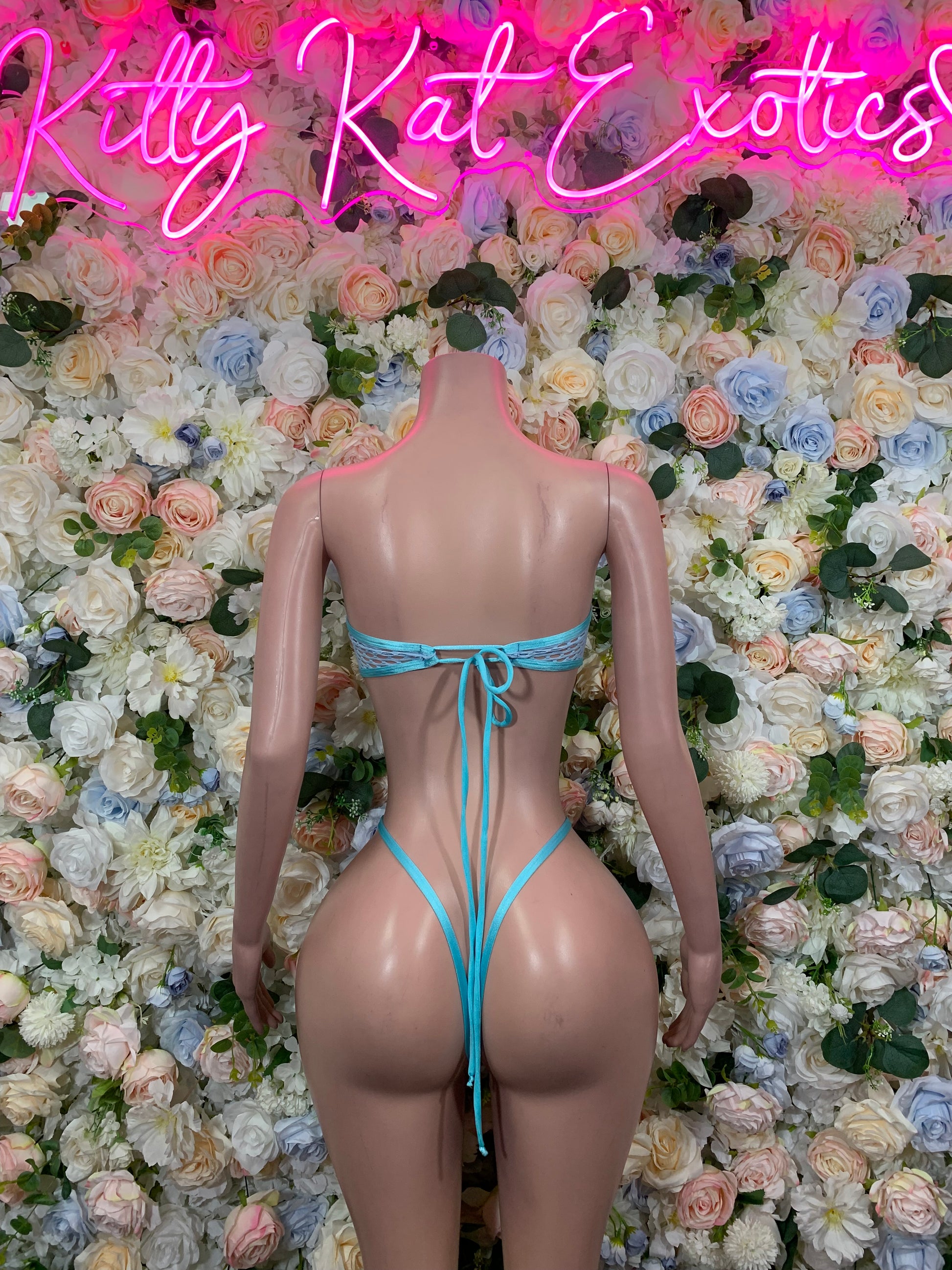 Teal fishnet festival bodysuit with lace-up tieback and open back, back view