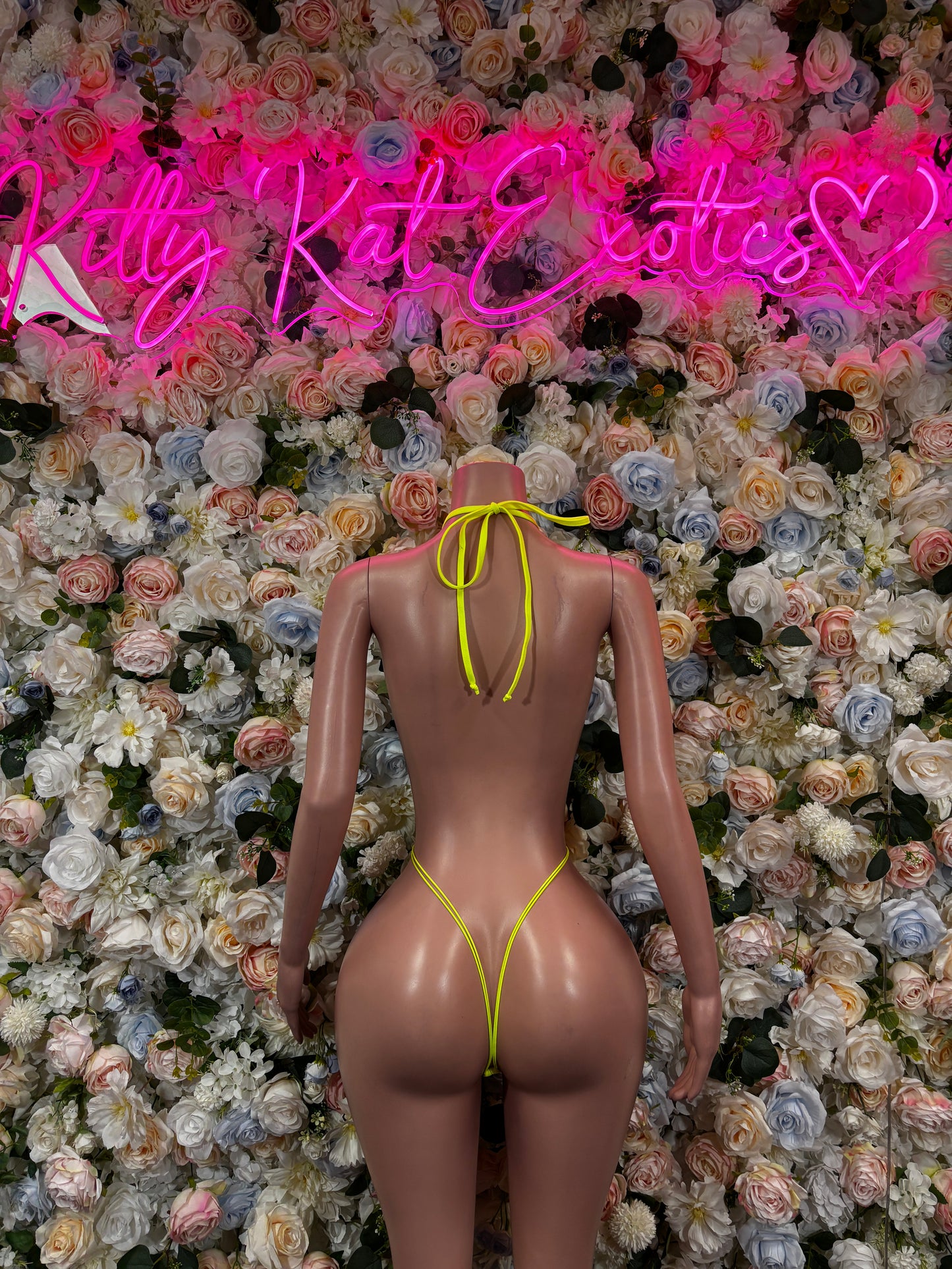 Neon yellow fishnet slingshot bodysuit with open back and thin crossover straps