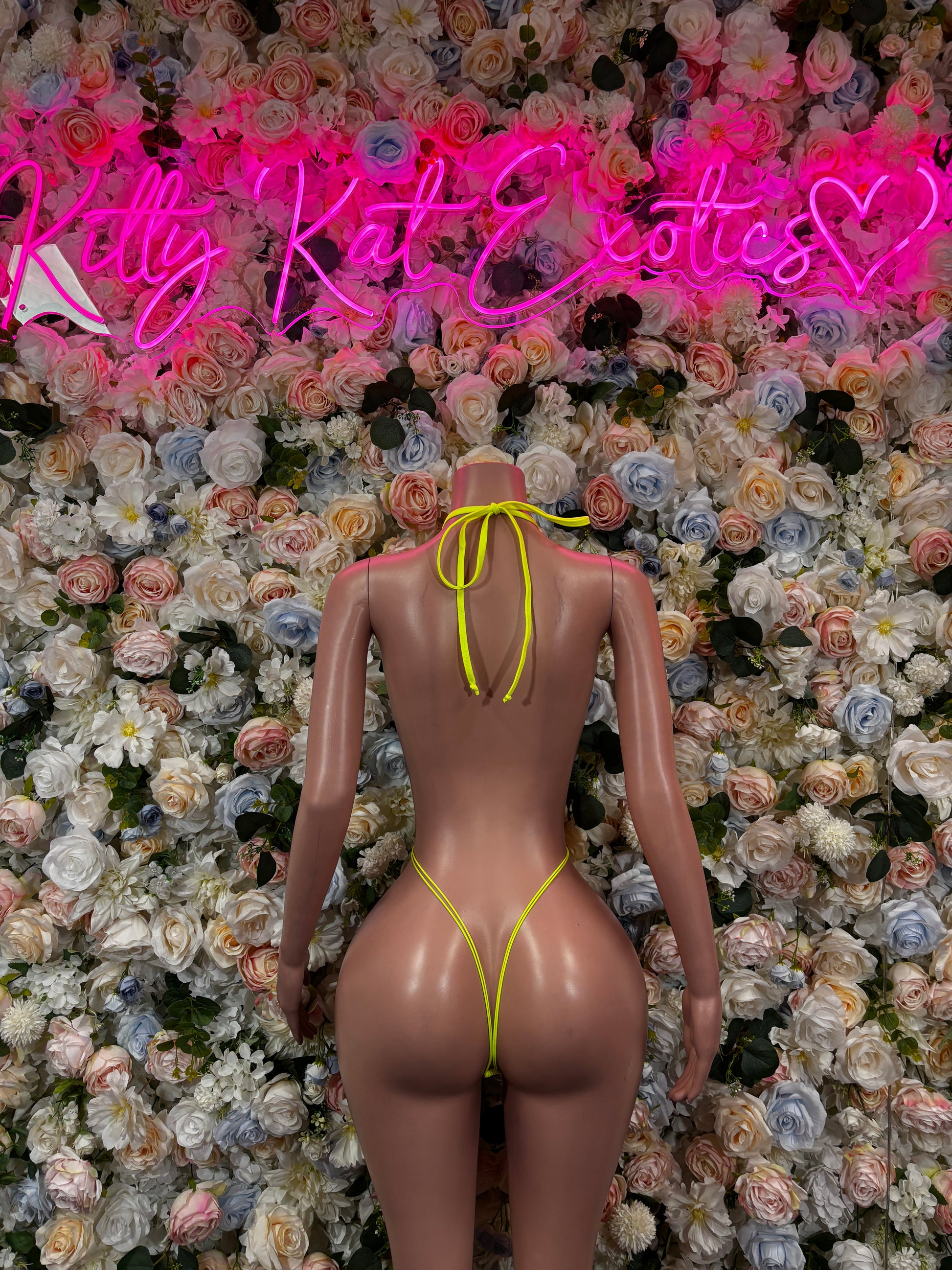 Neon yellow fishnet slingshot bodysuit with open back and thin crossover straps