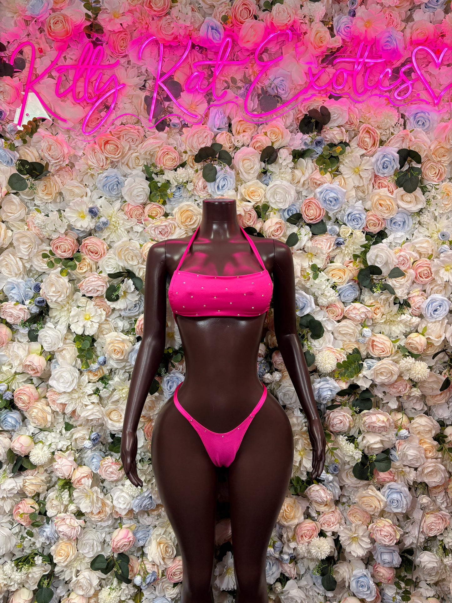 Pink two-piece bikini with sequined triangle top and string thong bottoms on mannequin