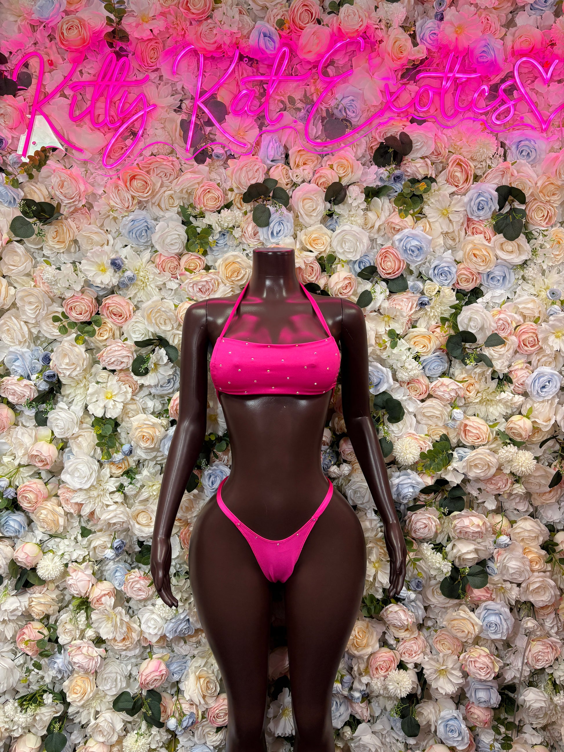 Pink two-piece bikini with sequined triangle top and string thong bottoms on mannequin