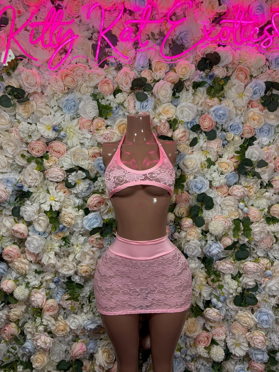 Pink lace halter crop top and mini skirt set on mannequin, lace overlay front