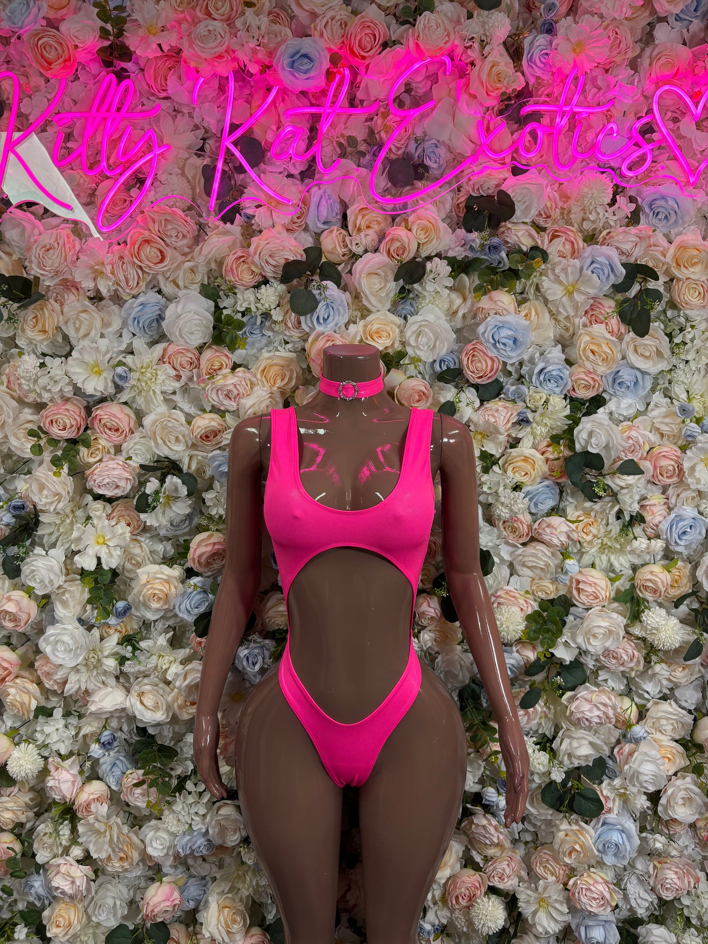 Pink one-piece bodysuit on mannequin, high-cut thong bottom and scoop front