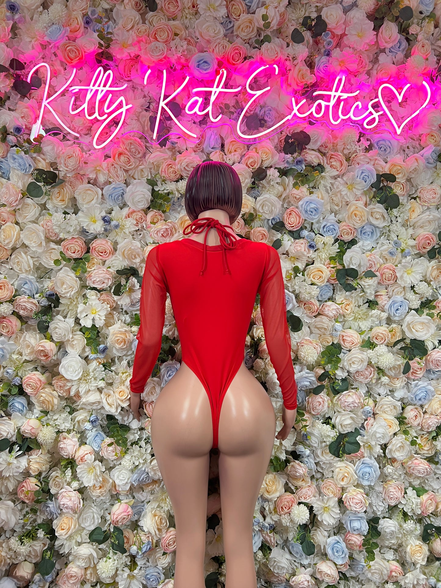 Back view of red heart-print lace-up bodysuit with long sleeves