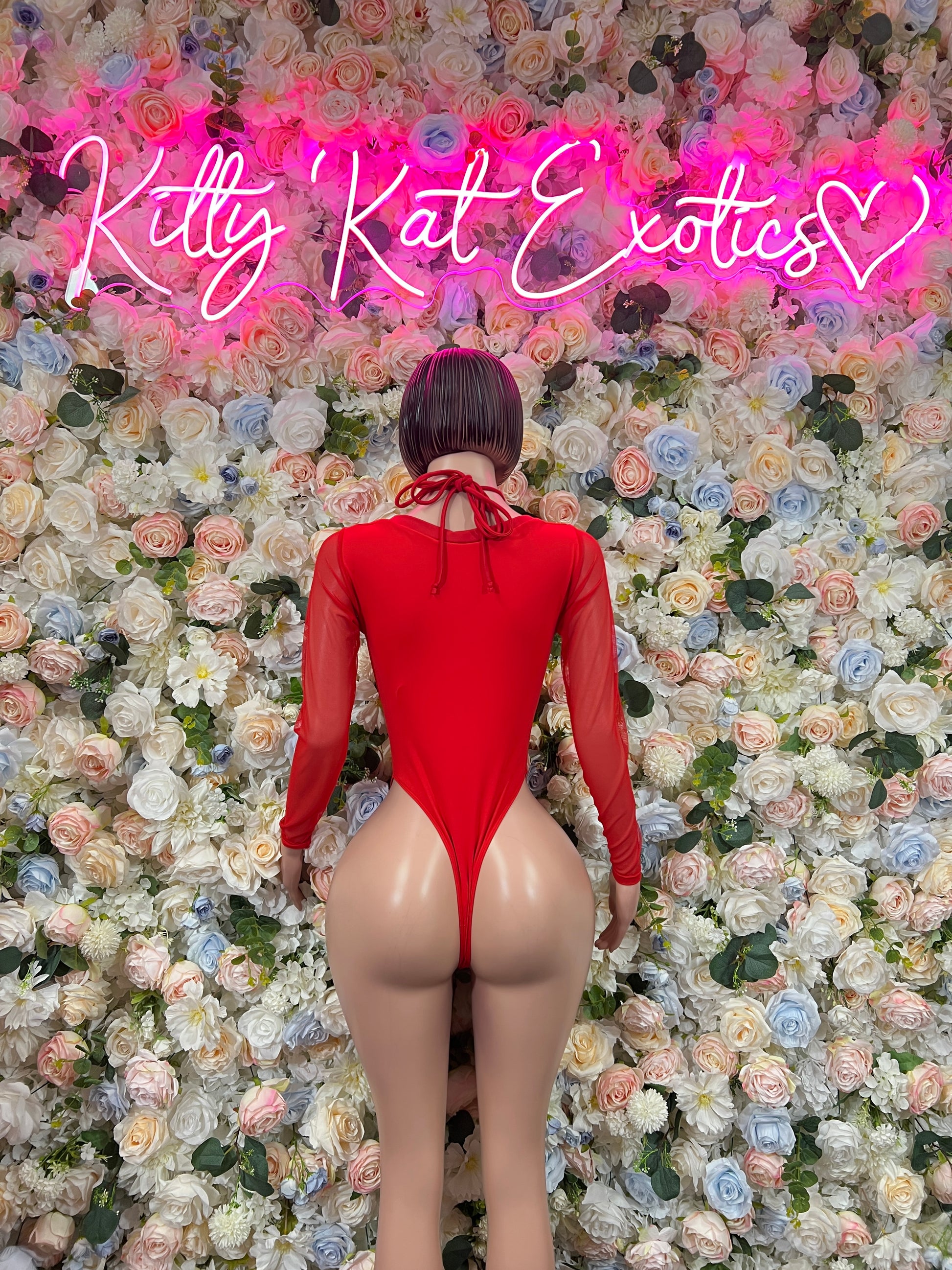 Back view of red heart-print lace-up bodysuit with long sleeves