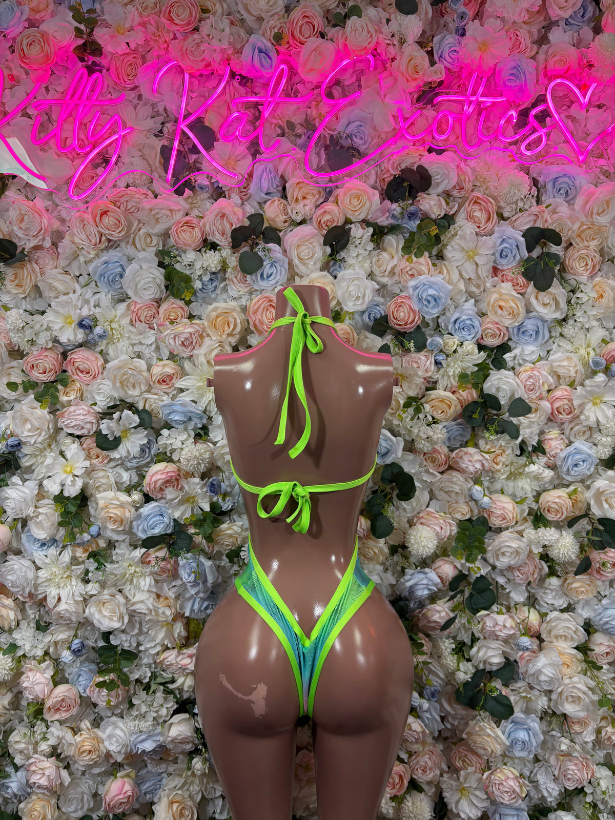 Neon green one-piece rave bodysuit with open back and high-cut leg openings