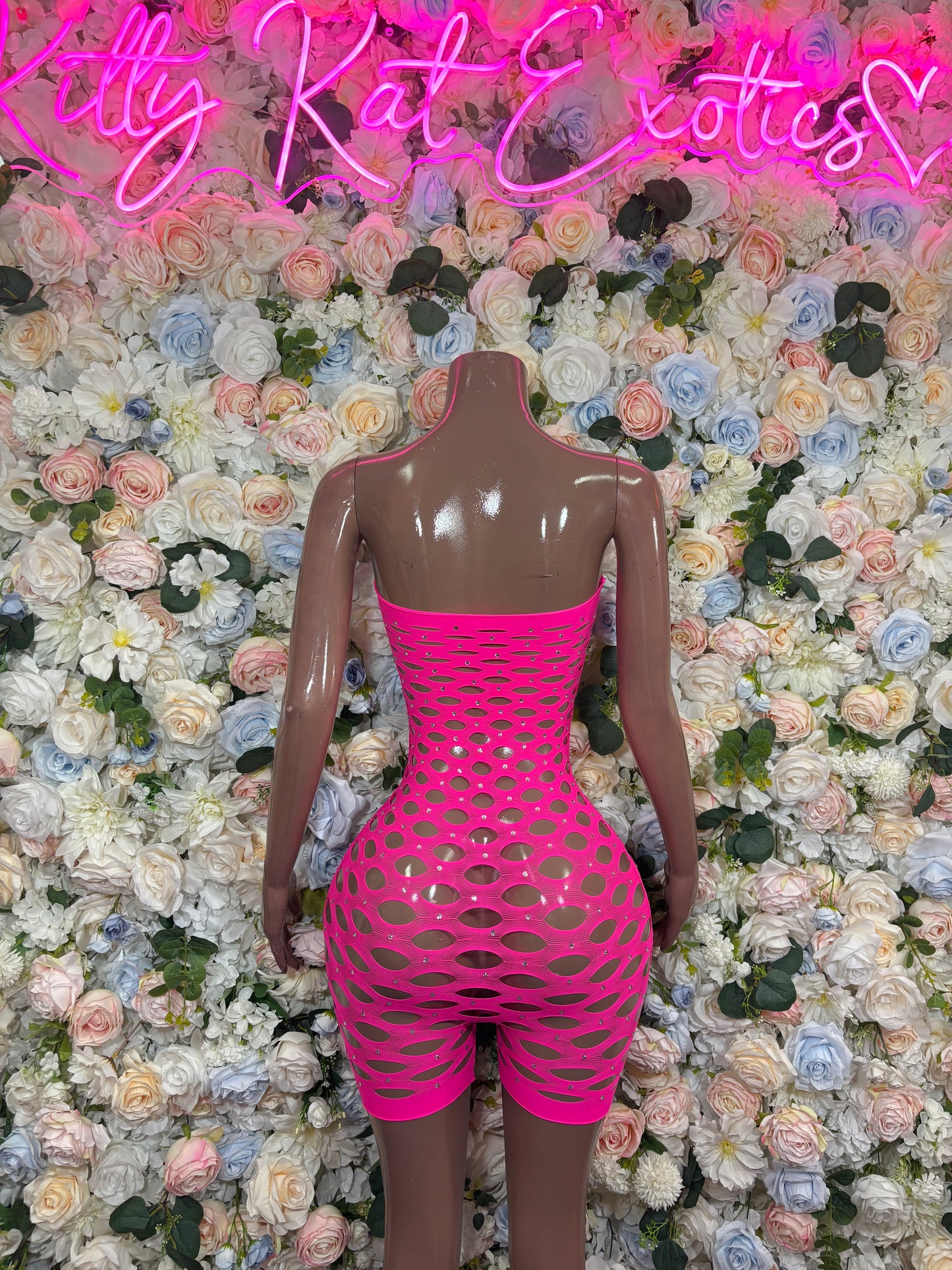 Hot pink fishnet strapless romper with circular pattern and open-back cutout
