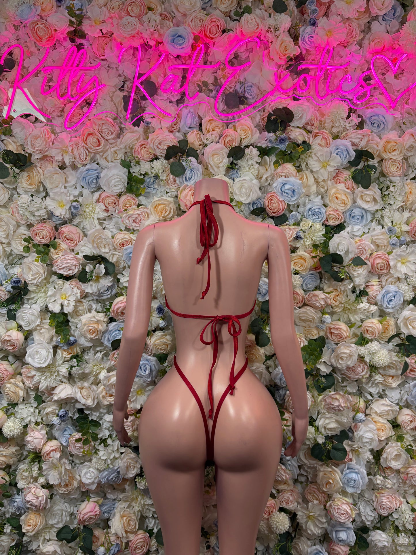 Green and red flag bodysuit with open back, crisscross straps, and tied waist