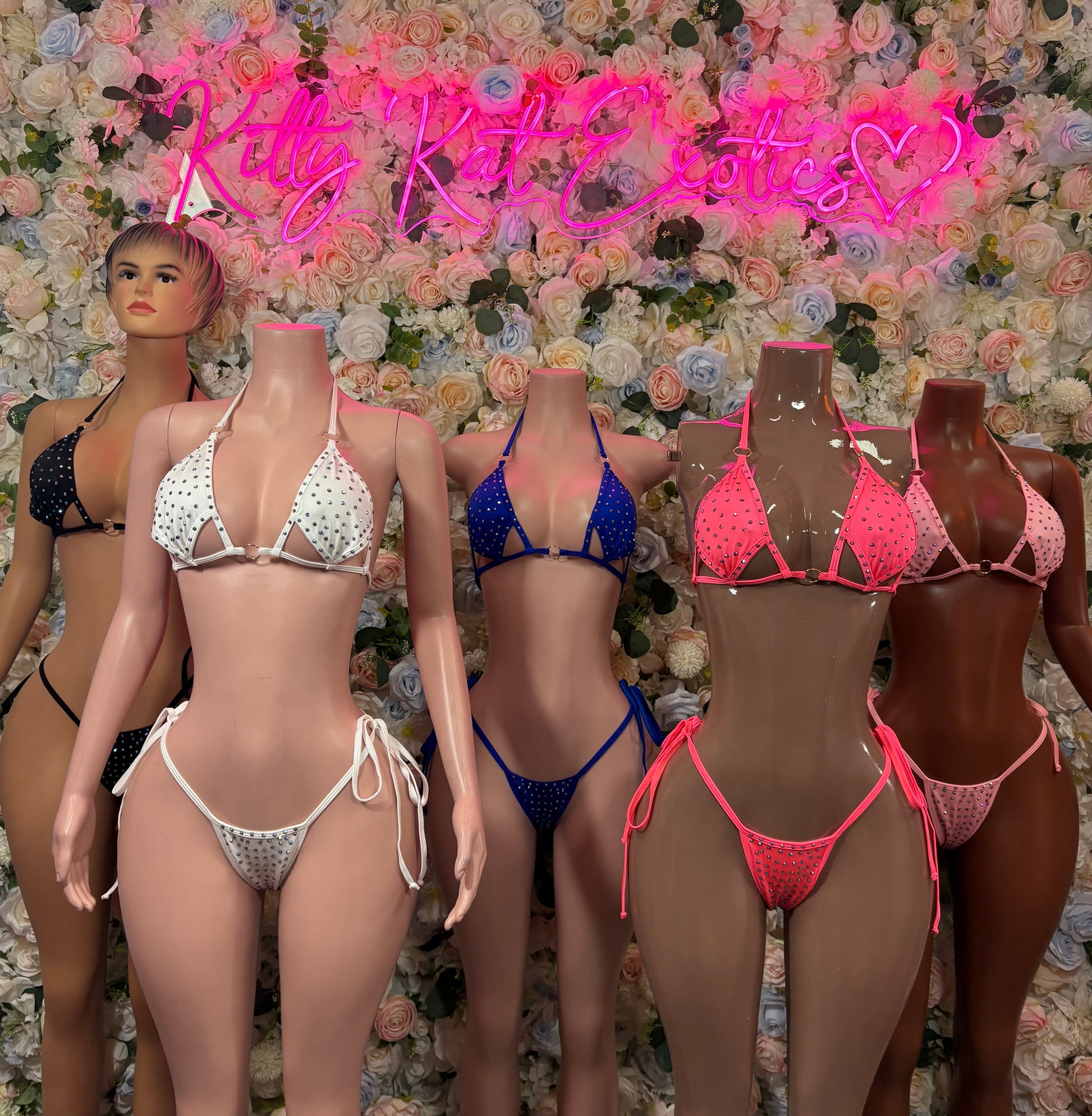 Assorted rhinestone triangle bikini sets on mannequins: white, blue, pink, and black