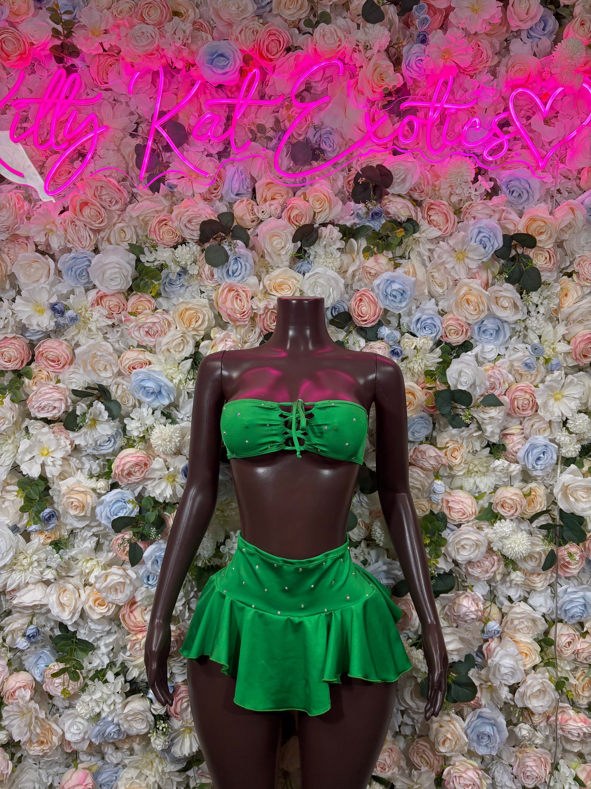 Green bandeau top with bow and matching ruffled mini skirt on mannequin