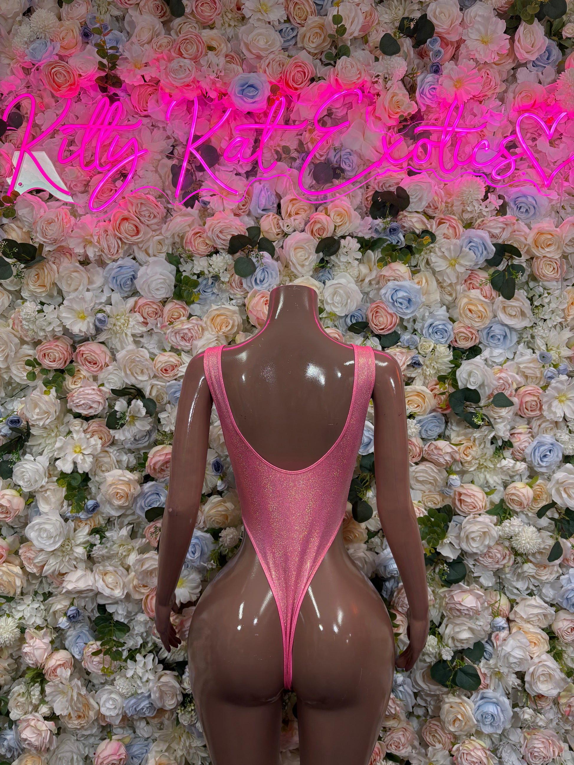 Pink glitter one-piece bodysuit with open chest and high-cut leg