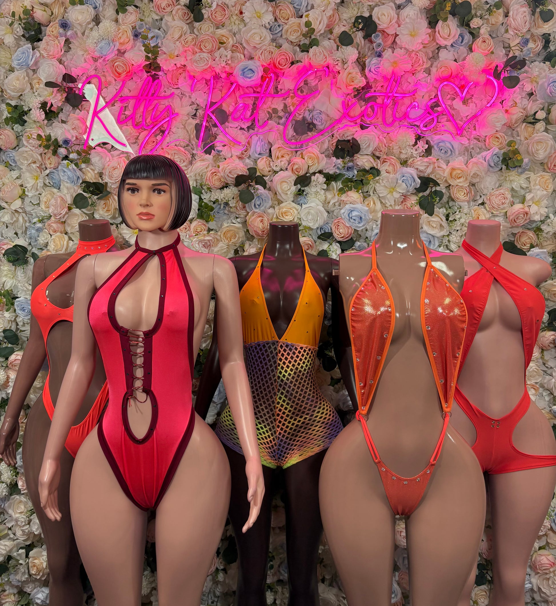 Halter one-piece bodysuits on models in orange, red, and yellow with cutout front