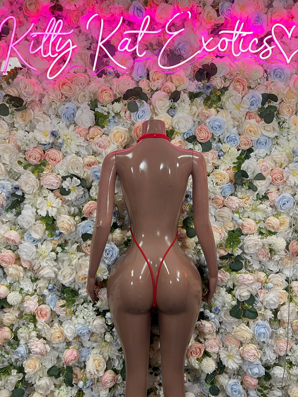 Red back-view slingshot bodysuit with thin straps and thong coverage