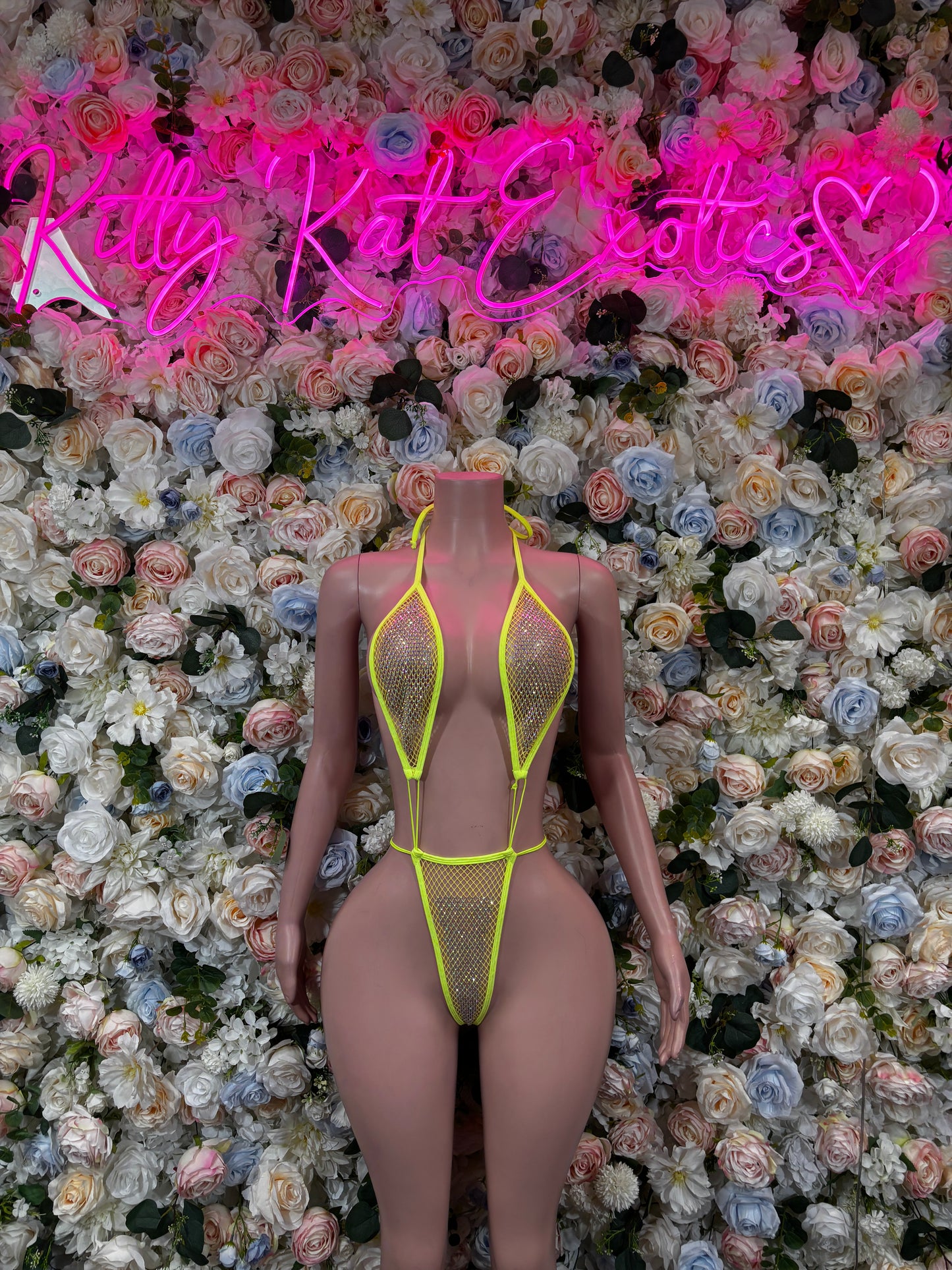 Neon yellow fishnet slingshot bodysuit with halter straps and high-cut legs