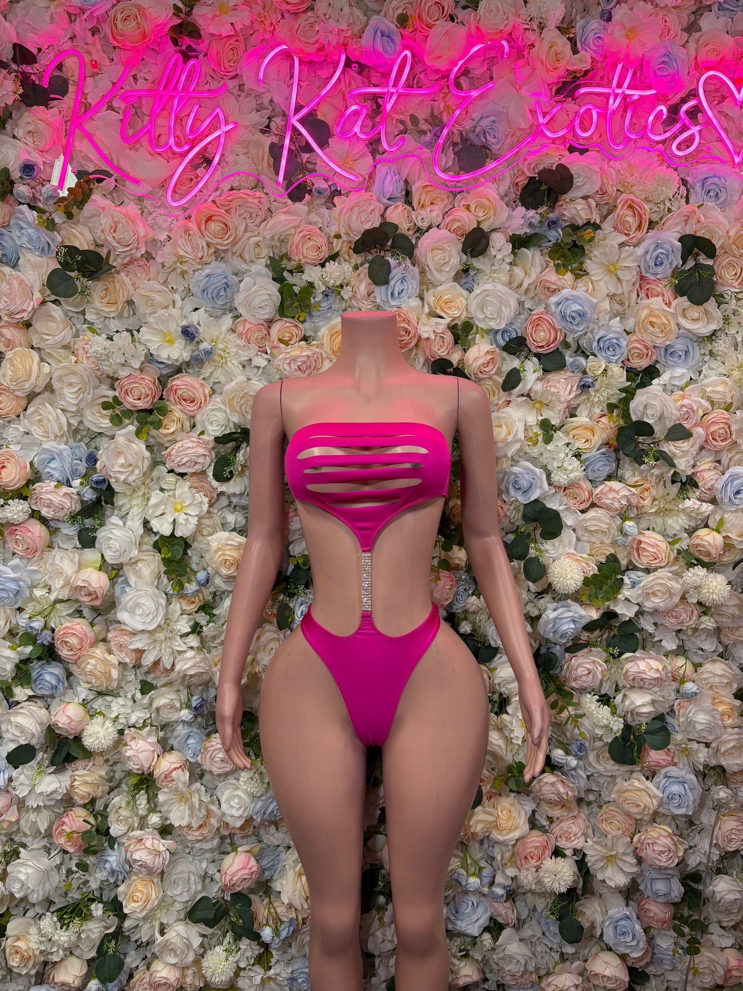 Pink two-piece bikini set with striped back cutout and thong bottoms, back view