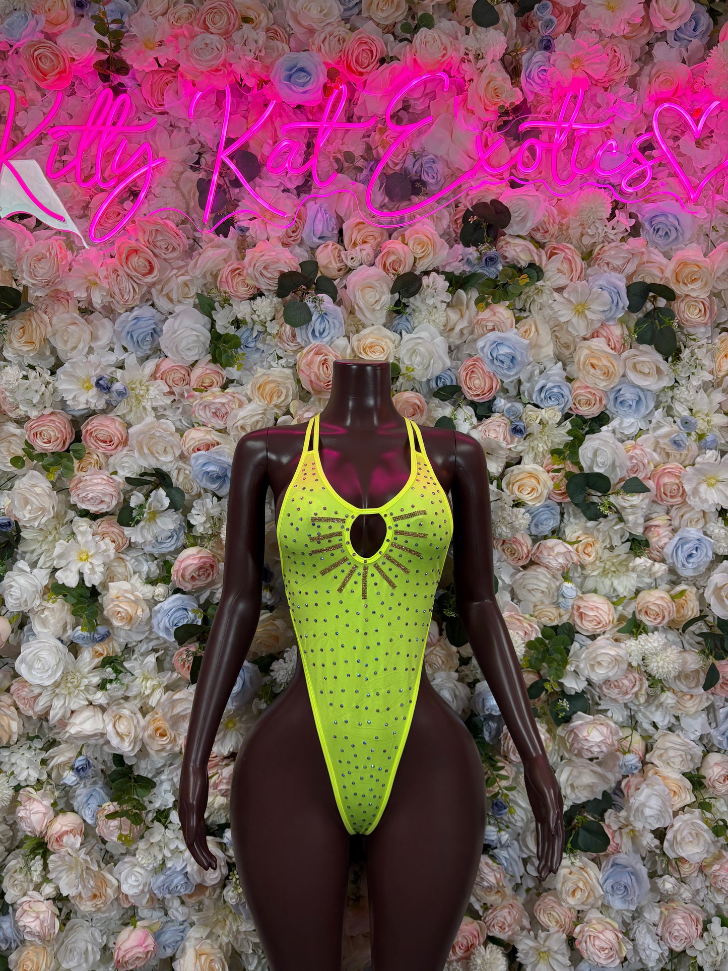 Neon green rhinestone bodysuit on mannequin, deep V-neck with circular chest detail