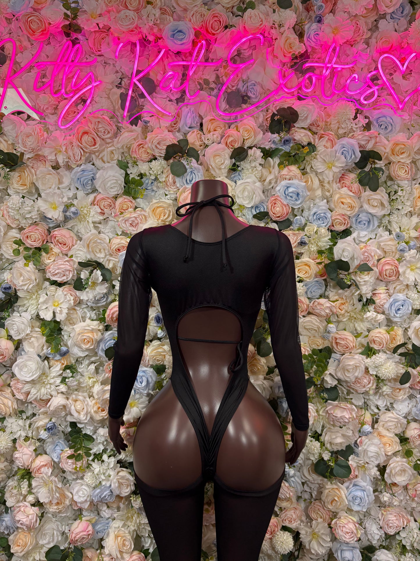 Black long-sleeve bodysuit with V-neck cutout, crisscross straps, and tie back