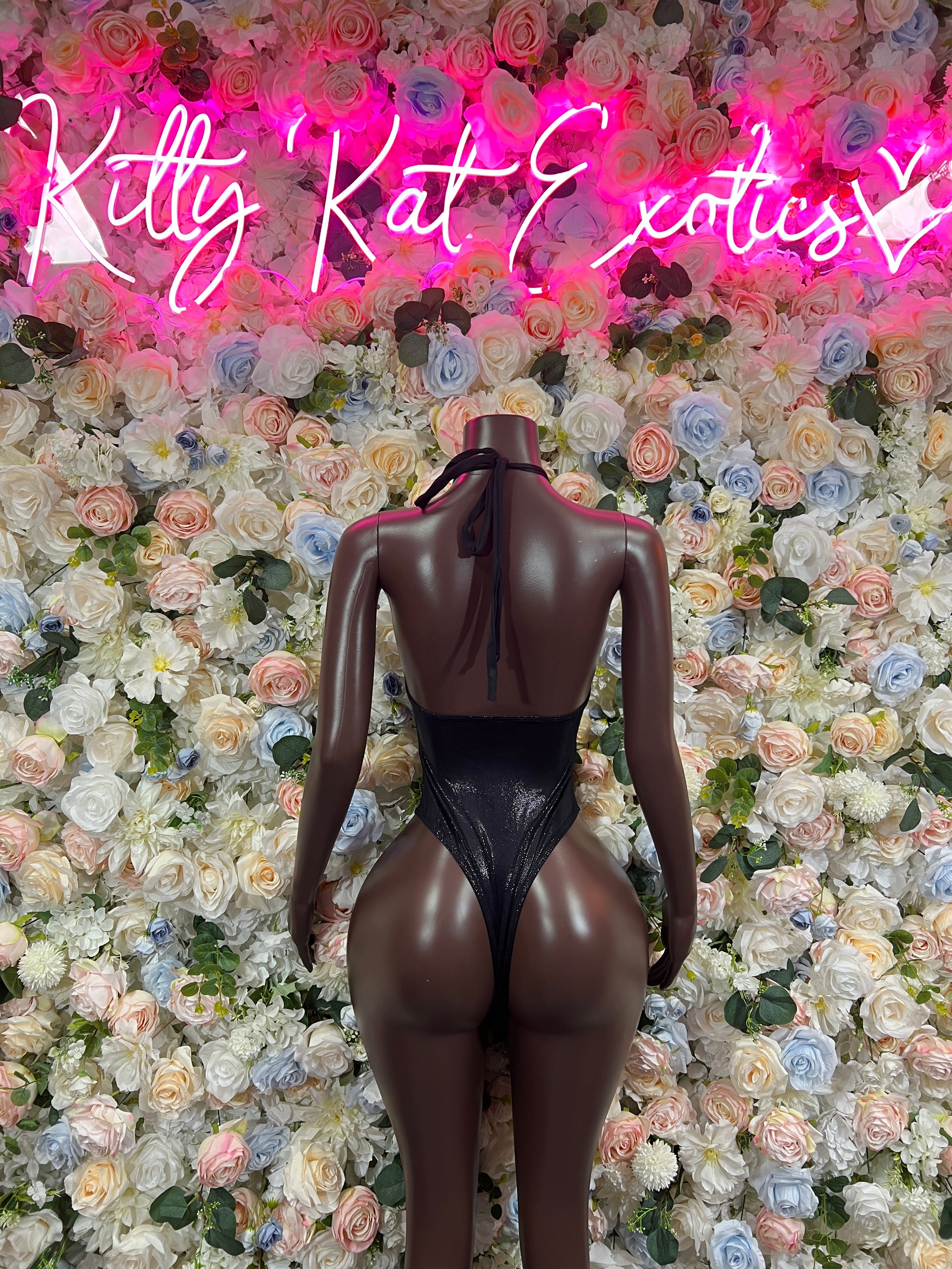 Black one-piece bodysuit with open back and high-leg cutout