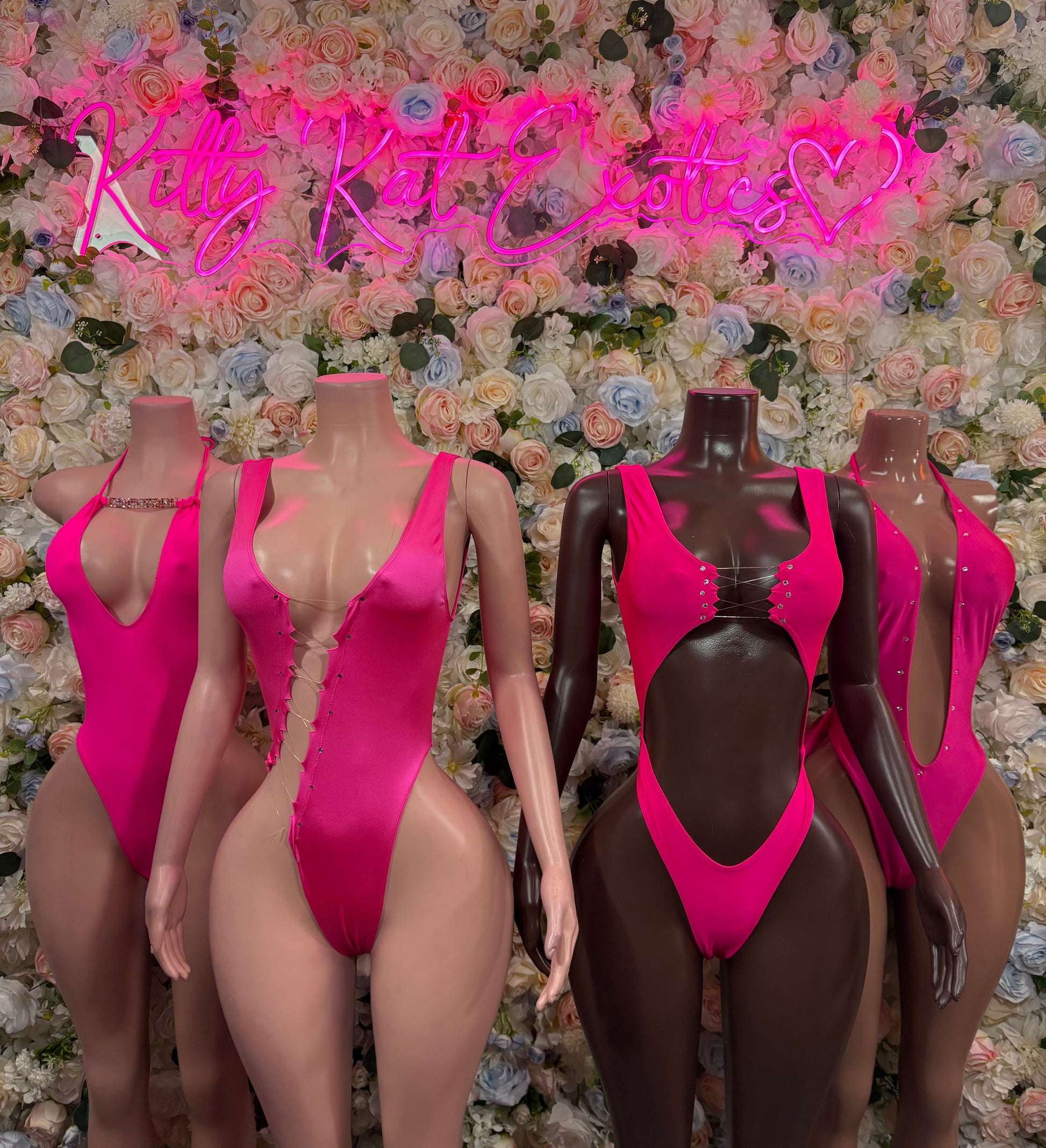 Set of pink sleeveless bodysuits on mannequins, high-cut thong style with V front
