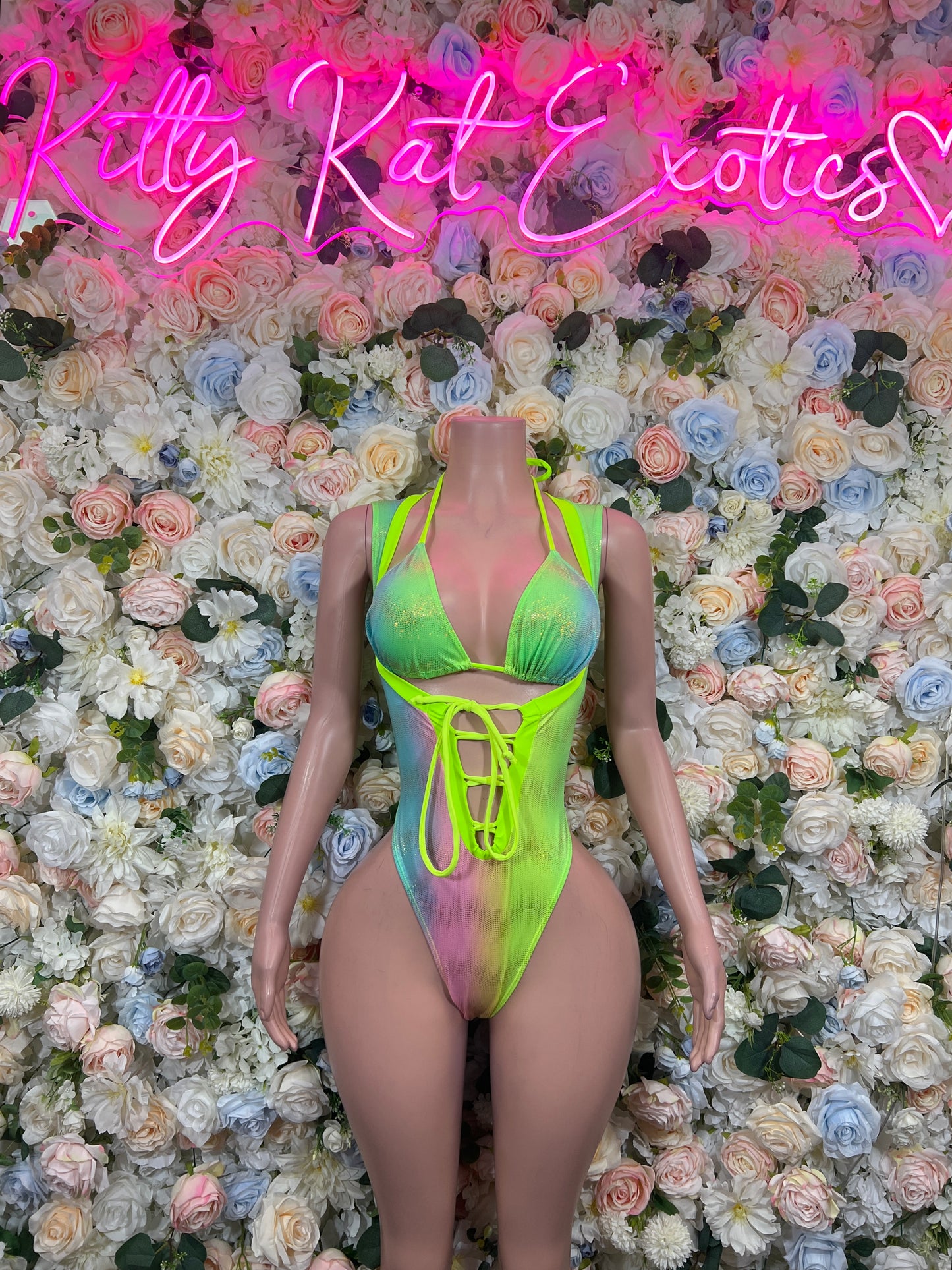 Holographic neon green lace-up bodysuit with crisscross front straps on mannequin