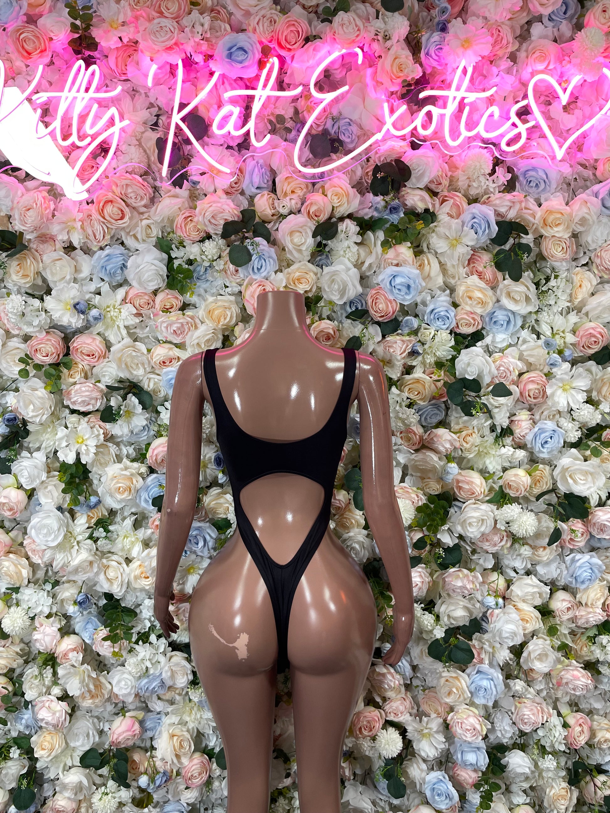 Black one-piece bodysuit with halter-style neckline and high-cut leg coverage.