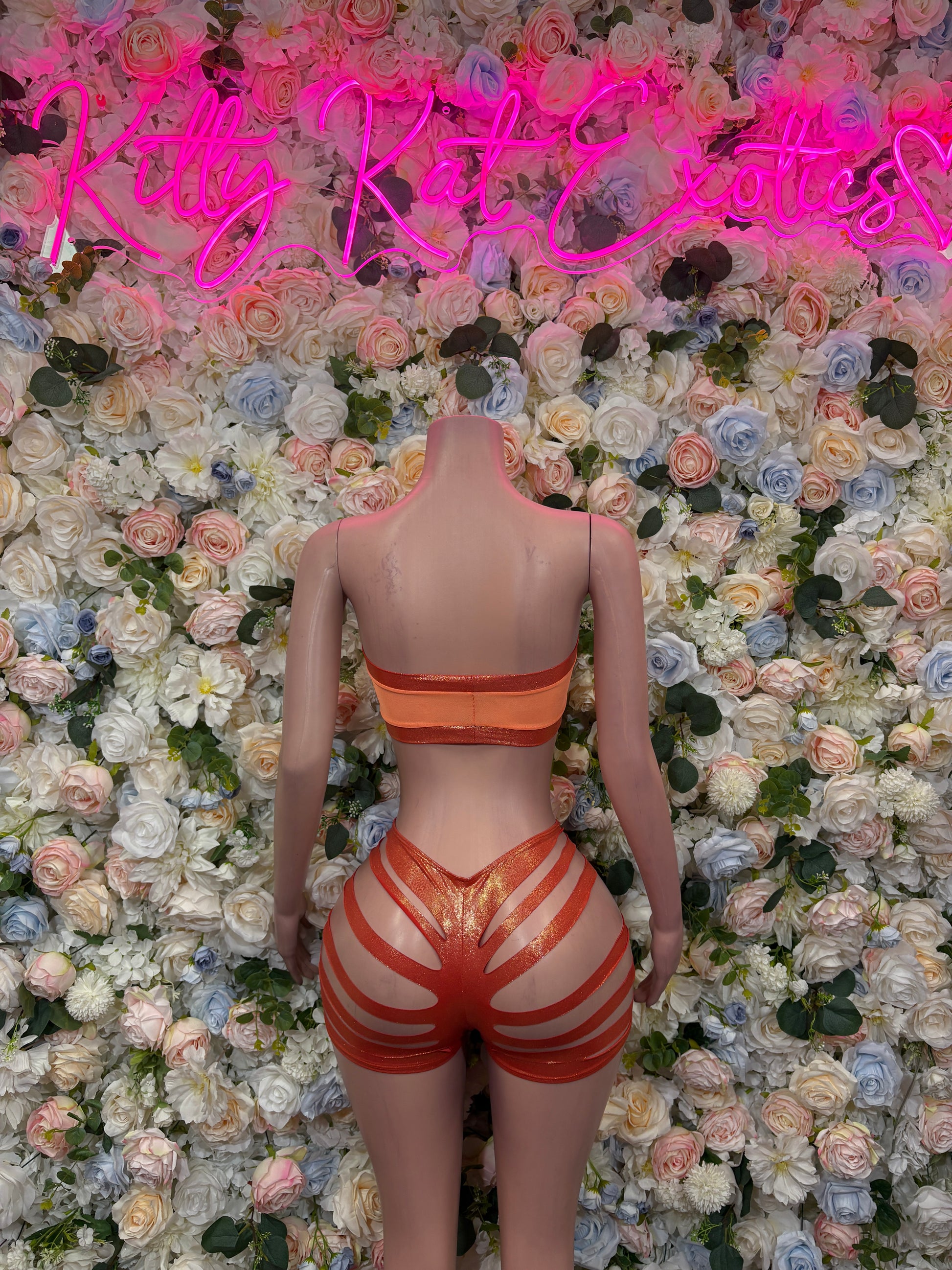 Orange bandeau crop top and striped high-waist shorts, front view