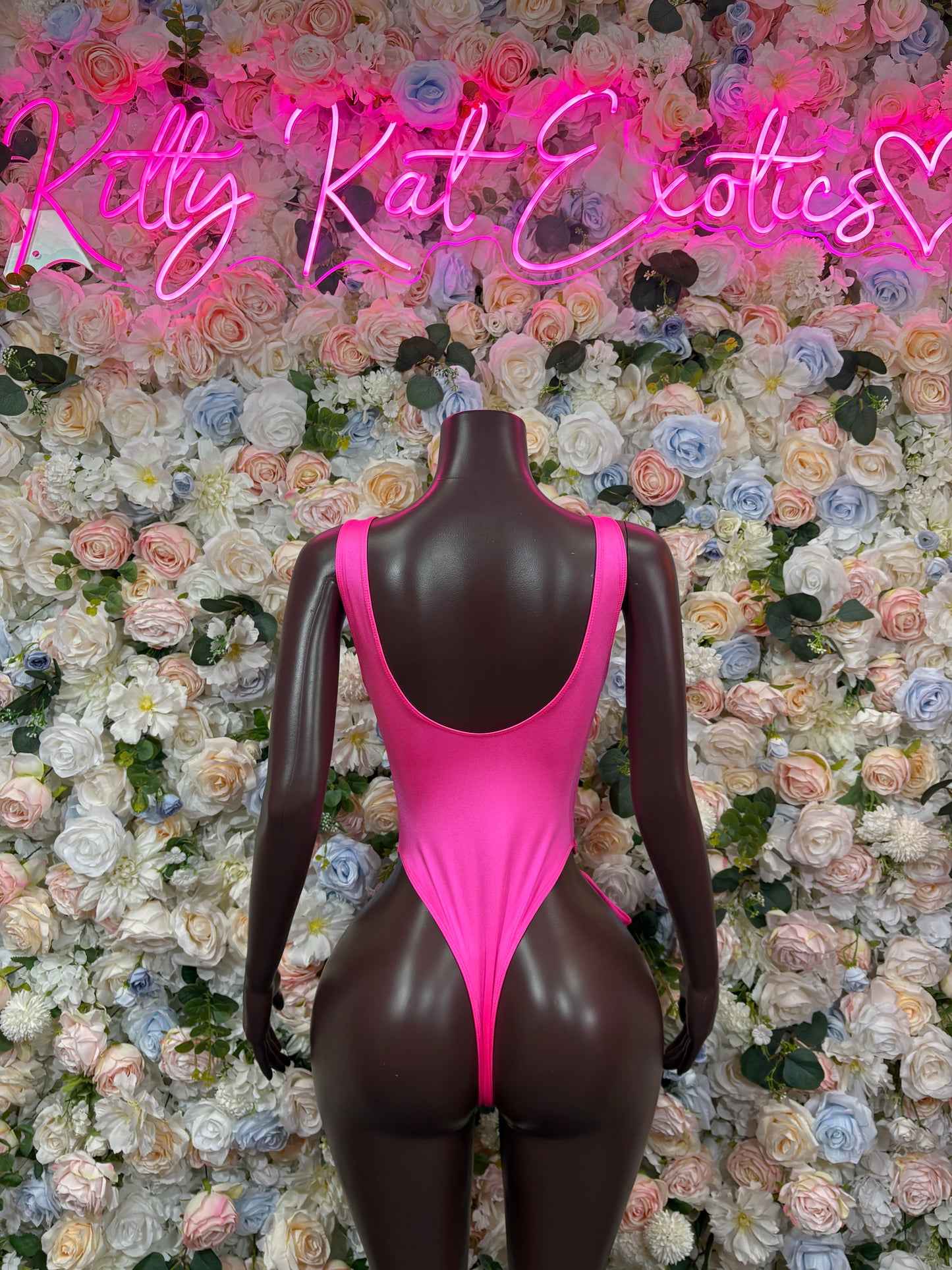 Pink one-piece bodysuit with open back and narrow straps