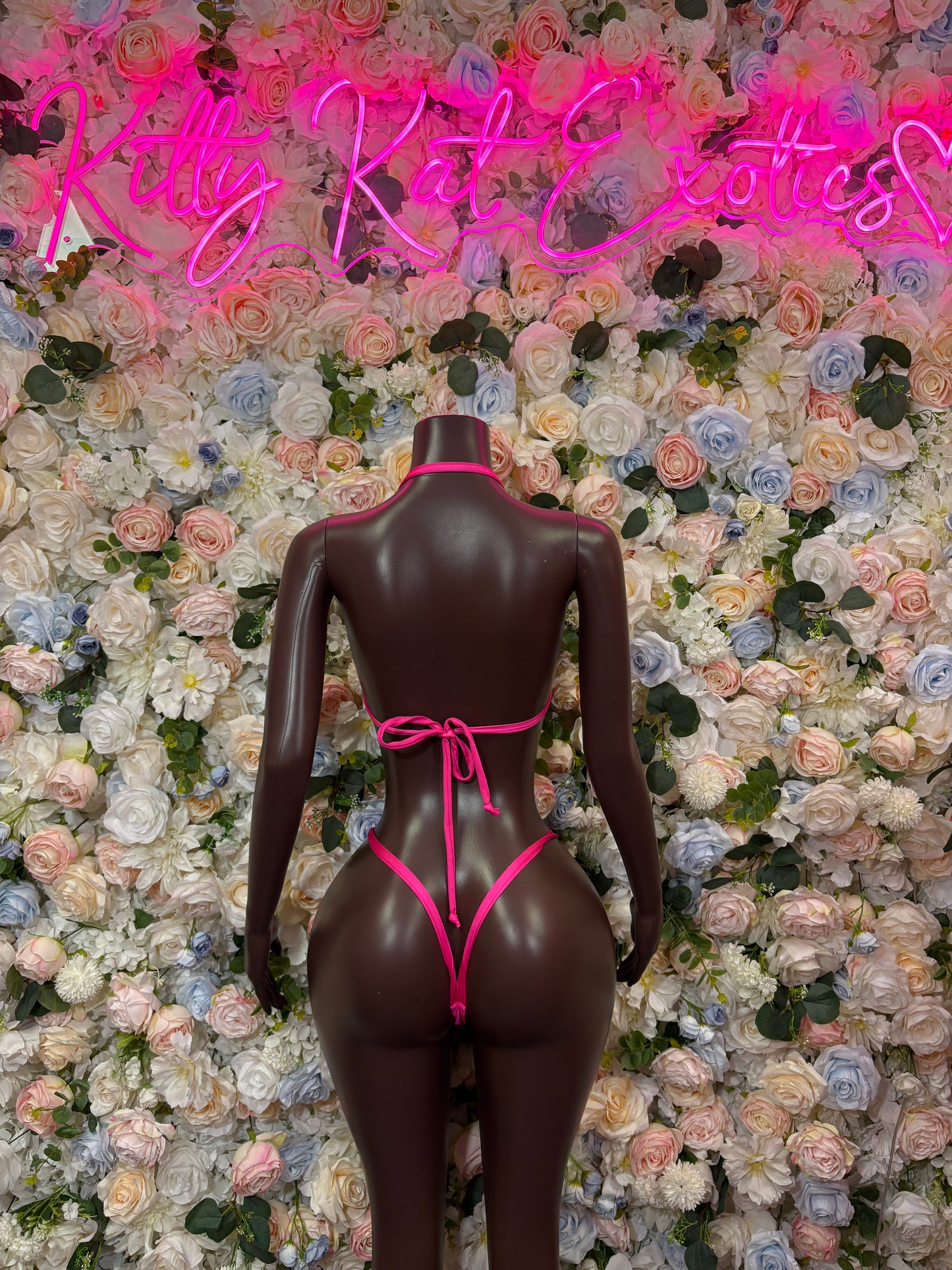 Pink bikini set with triangle top and tie-back thong bottoms on mannequin