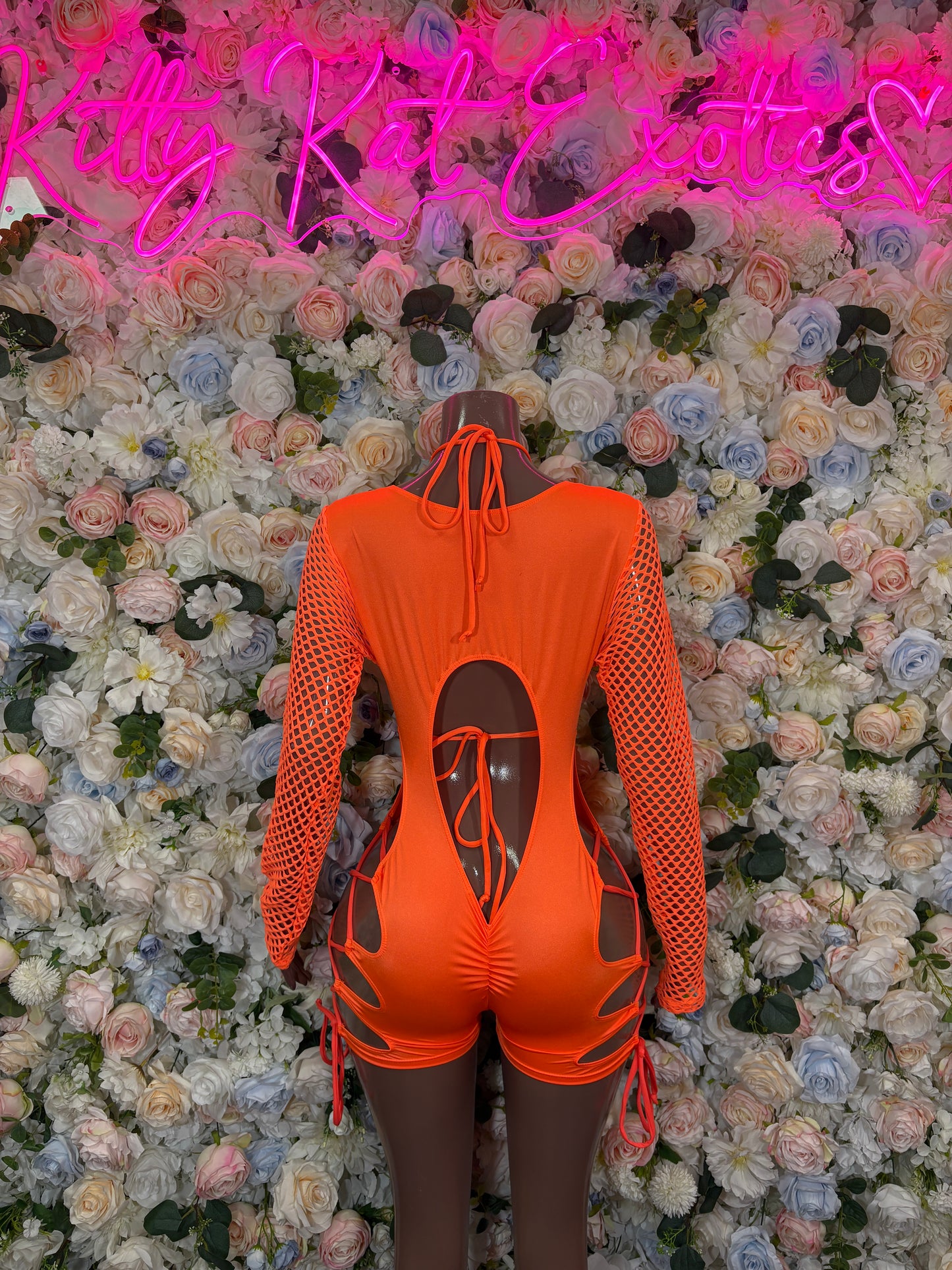 Orange one-piece bodysuit with mesh long sleeves and back cutouts, lace-up sides