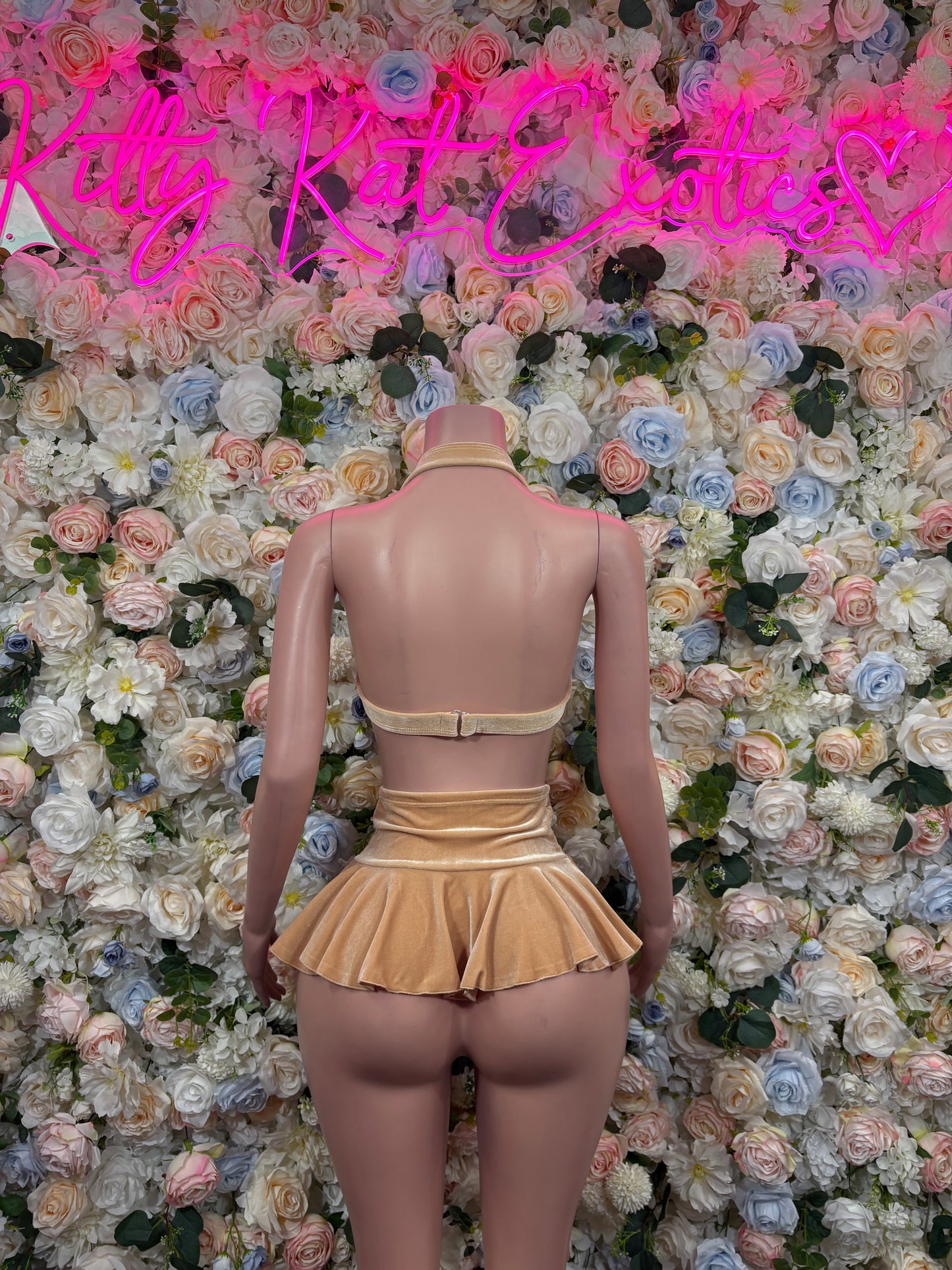 Nude velvet two-piece skirt set, back view with tie straps and flared mini skirt