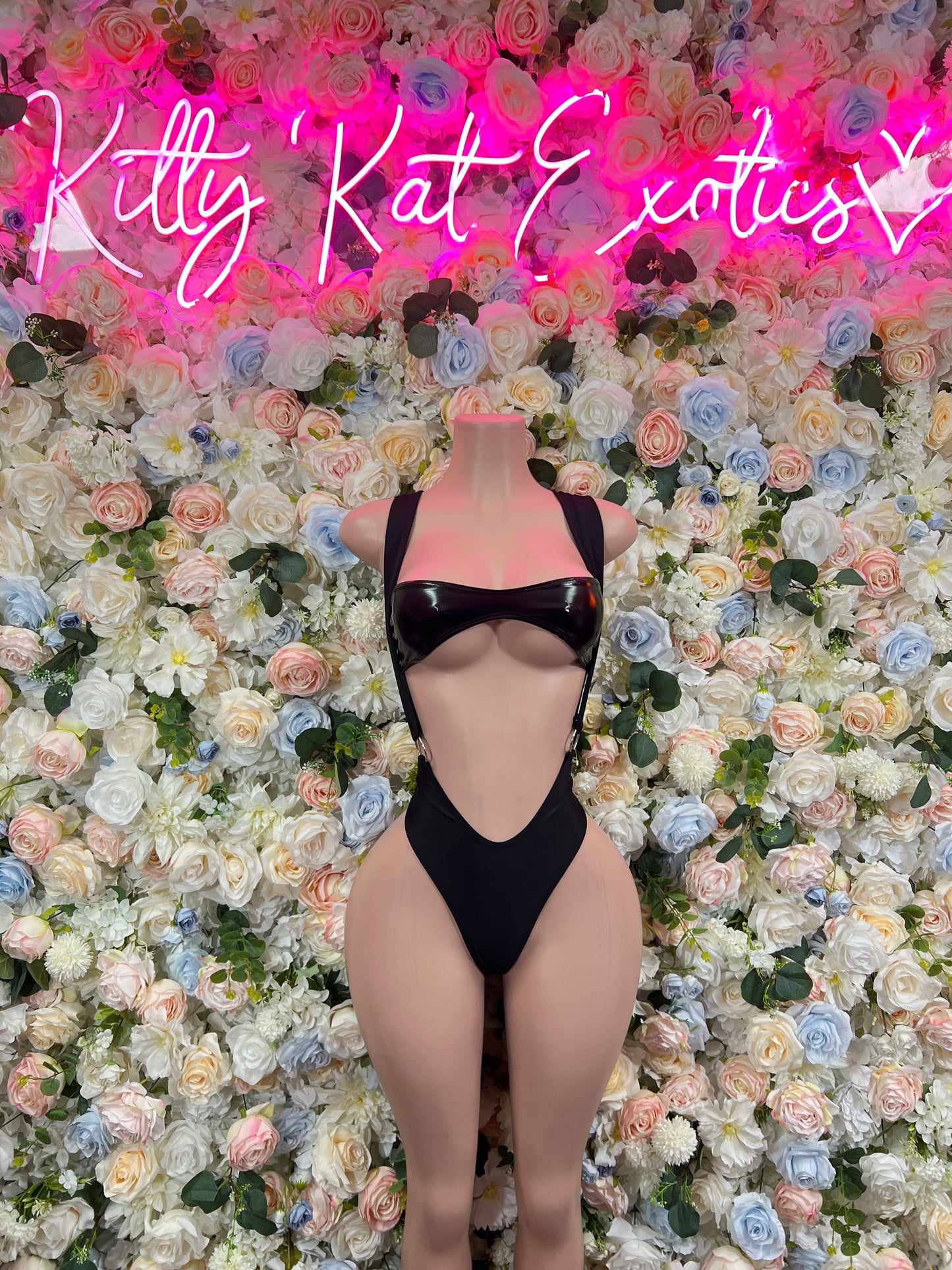Black one-piece bodysuit with cheeky cutout front and strap detailing