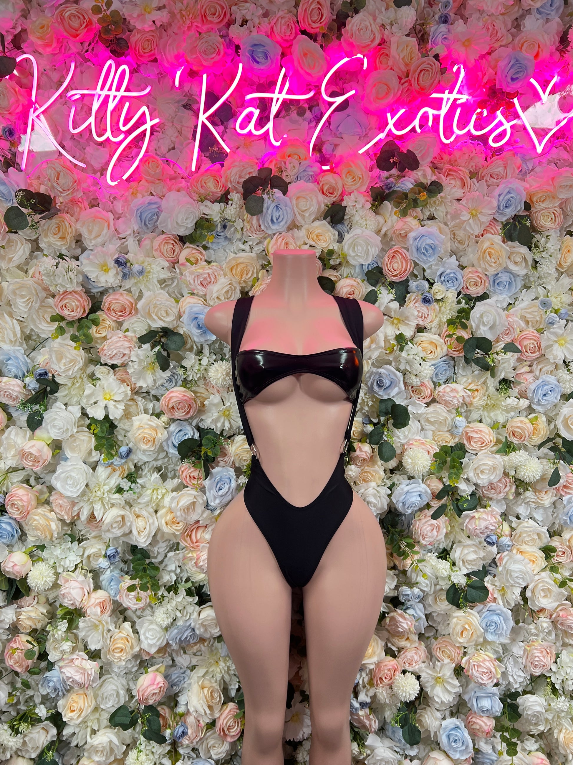 Black one-piece bodysuit with cheeky cutout front and strap detailing