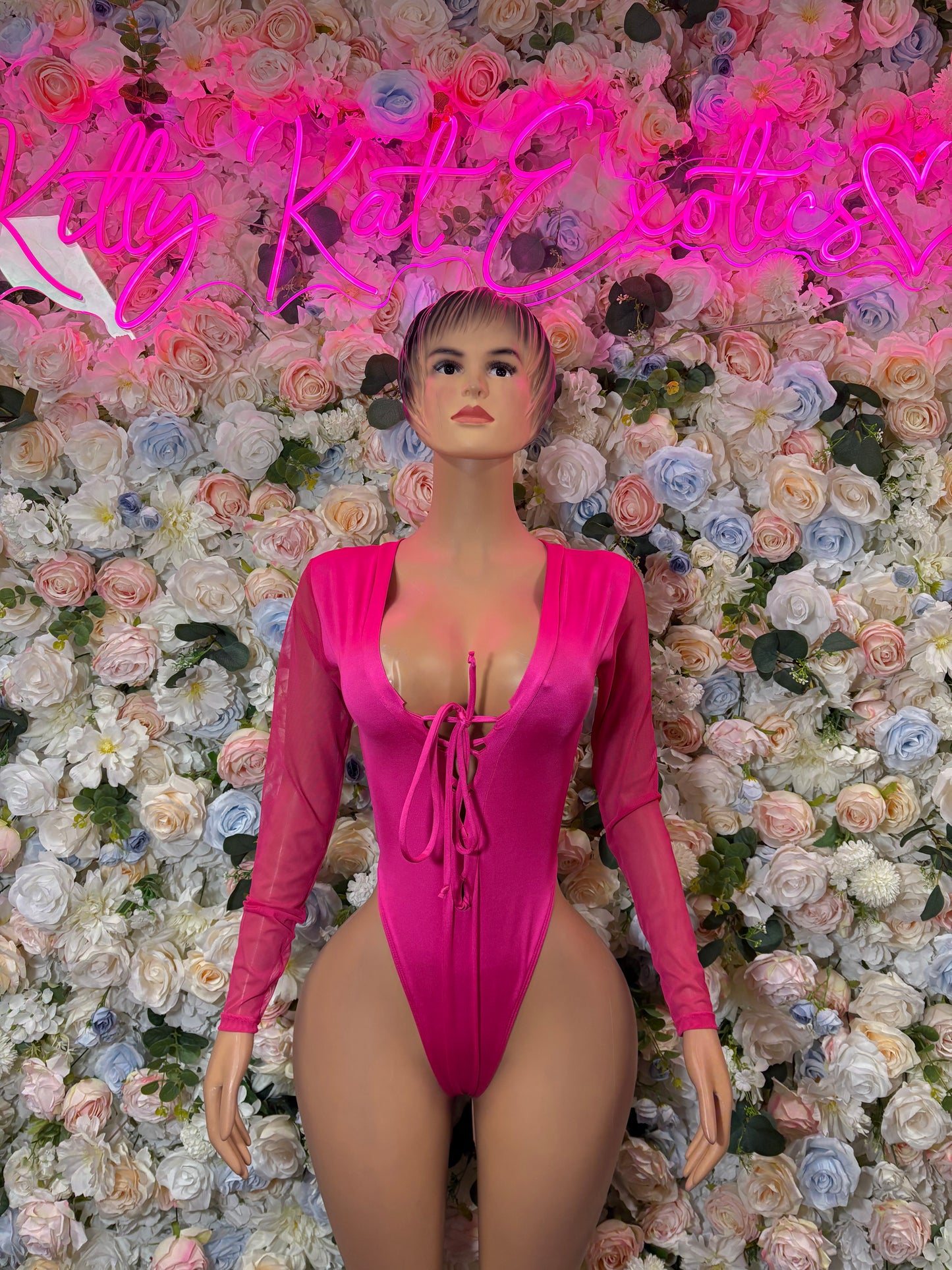 Hot pink long-sleeve bodysuit with plunging neckline and lace-up front, fitted stretch fabric