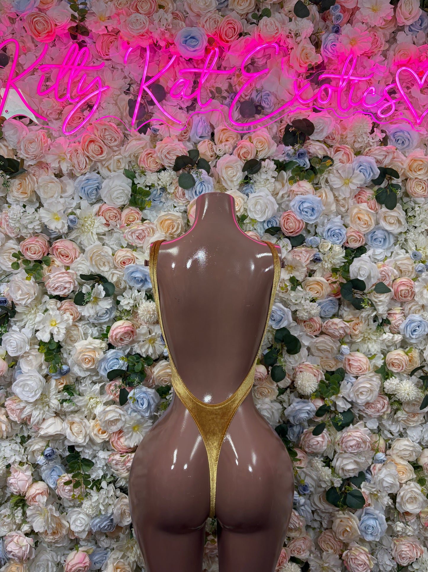 Gold metallic bodysuit on mannequin, high-cut thong back and low waist