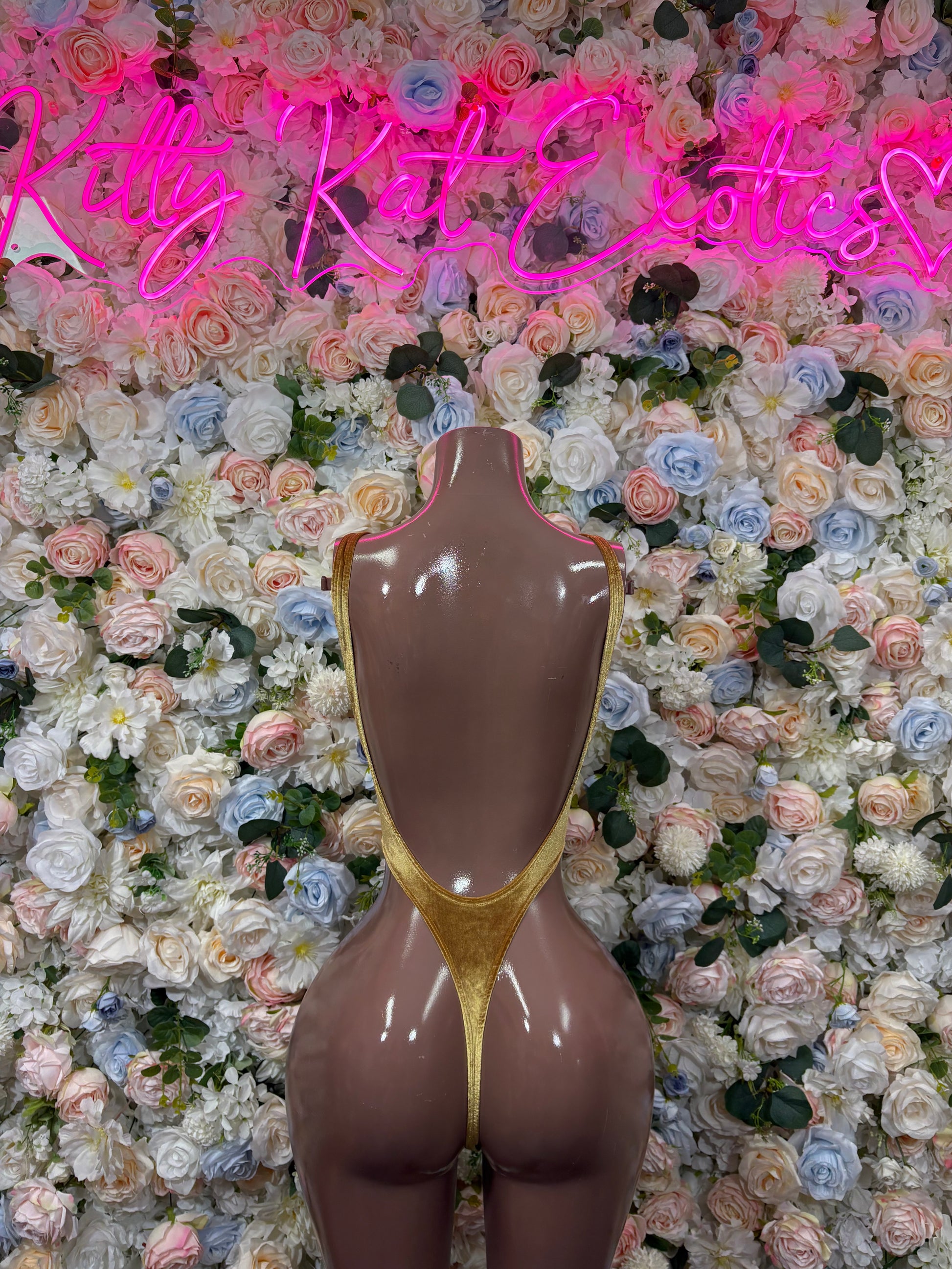 Gold metallic bodysuit on mannequin, high-cut thong back and low waist
