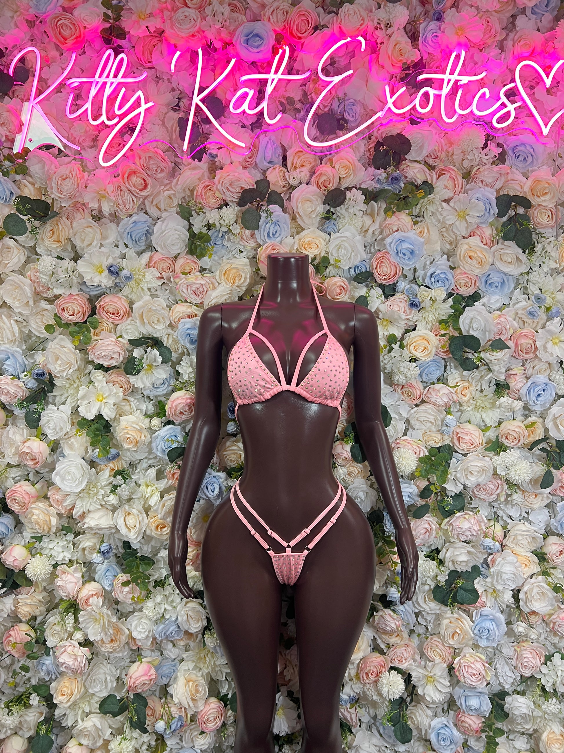 Pink rhinestone bikini set with triangle top and matching thong bottoms on mannequin