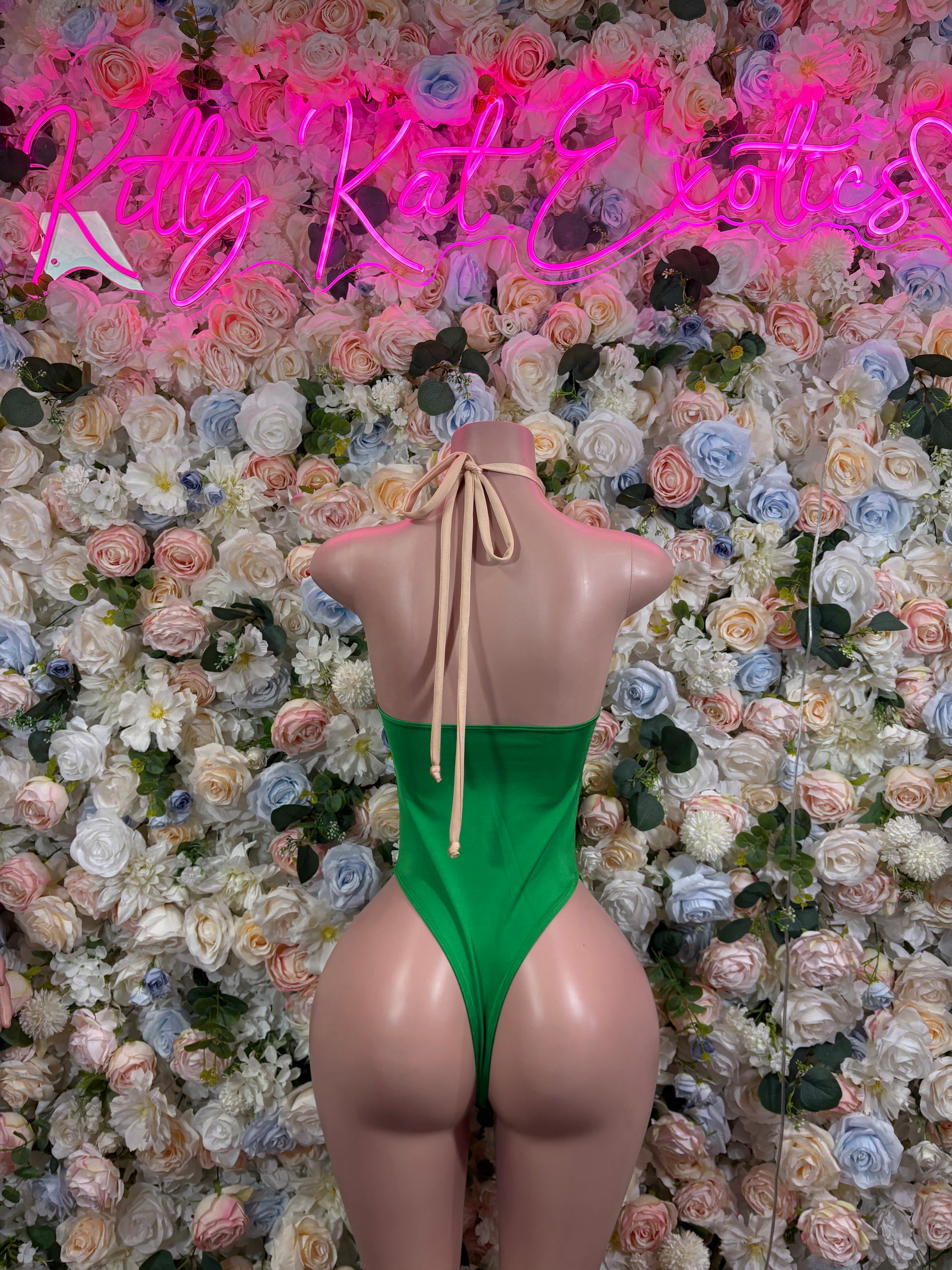 Back view of green halter bodysuit with center lace-up tie
