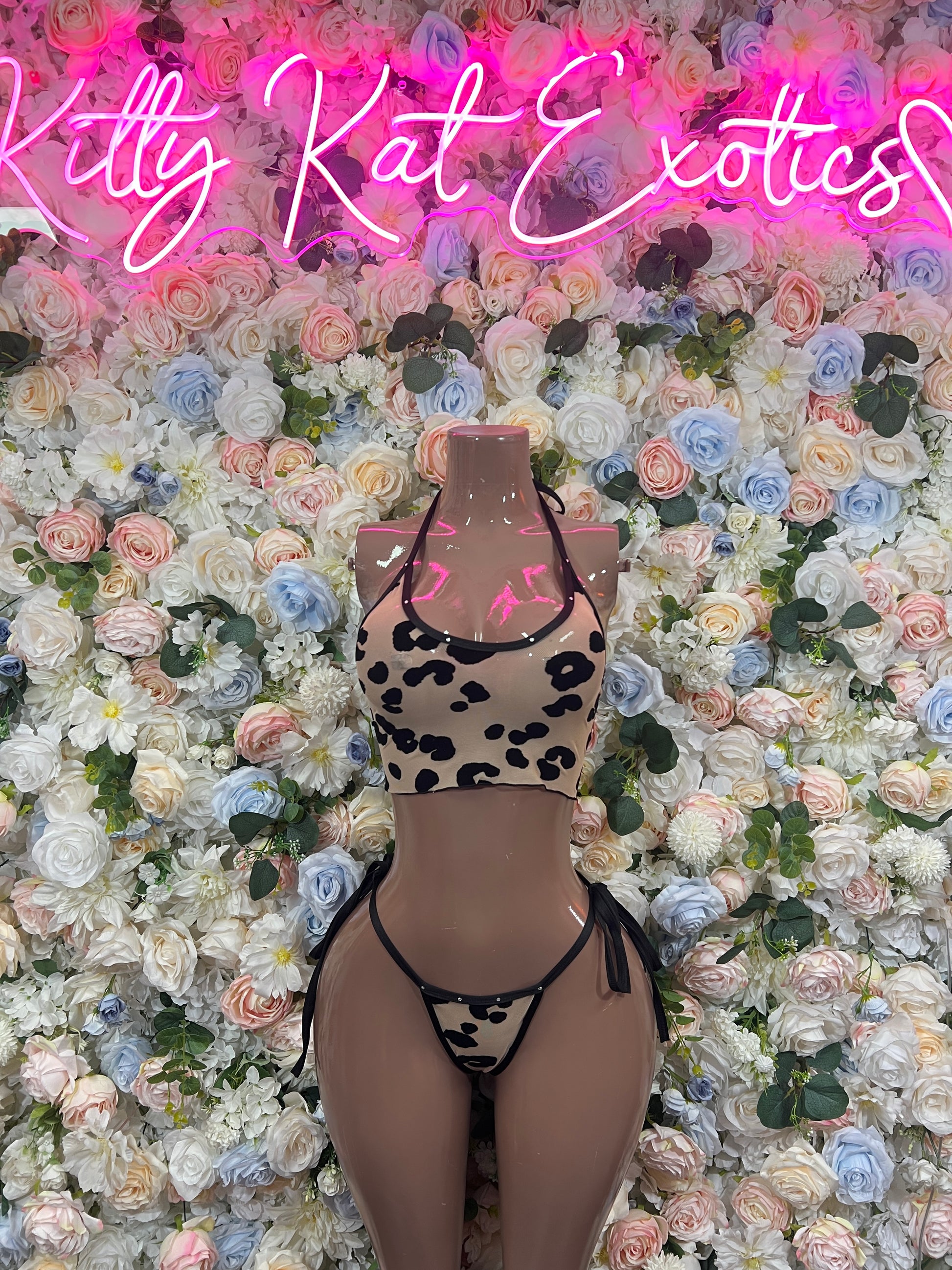 Leopard-print two-piece bikini set with black halter top and matching string bottoms