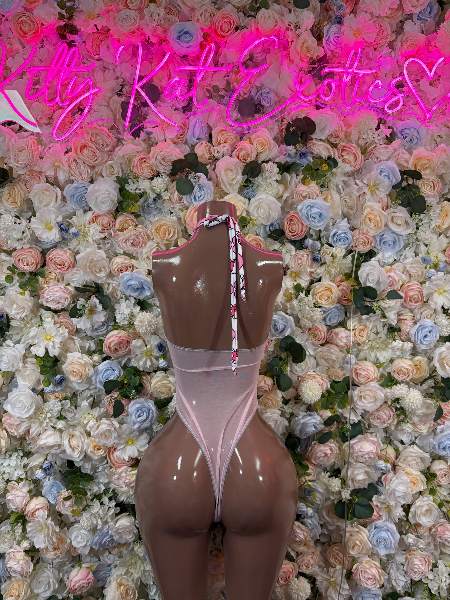 Pink bodysuit with heart accents, high-cut legs, and sheer back panel