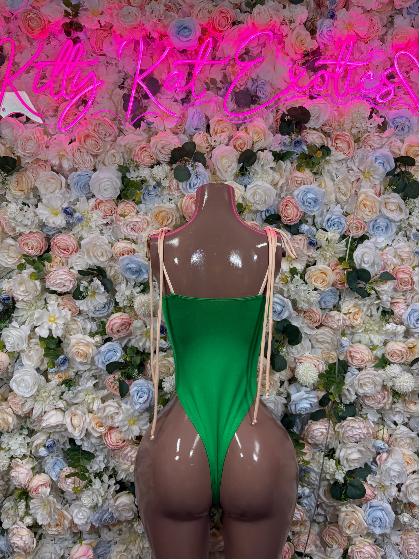 Green bodysuit with open back and lace-up strap detailing