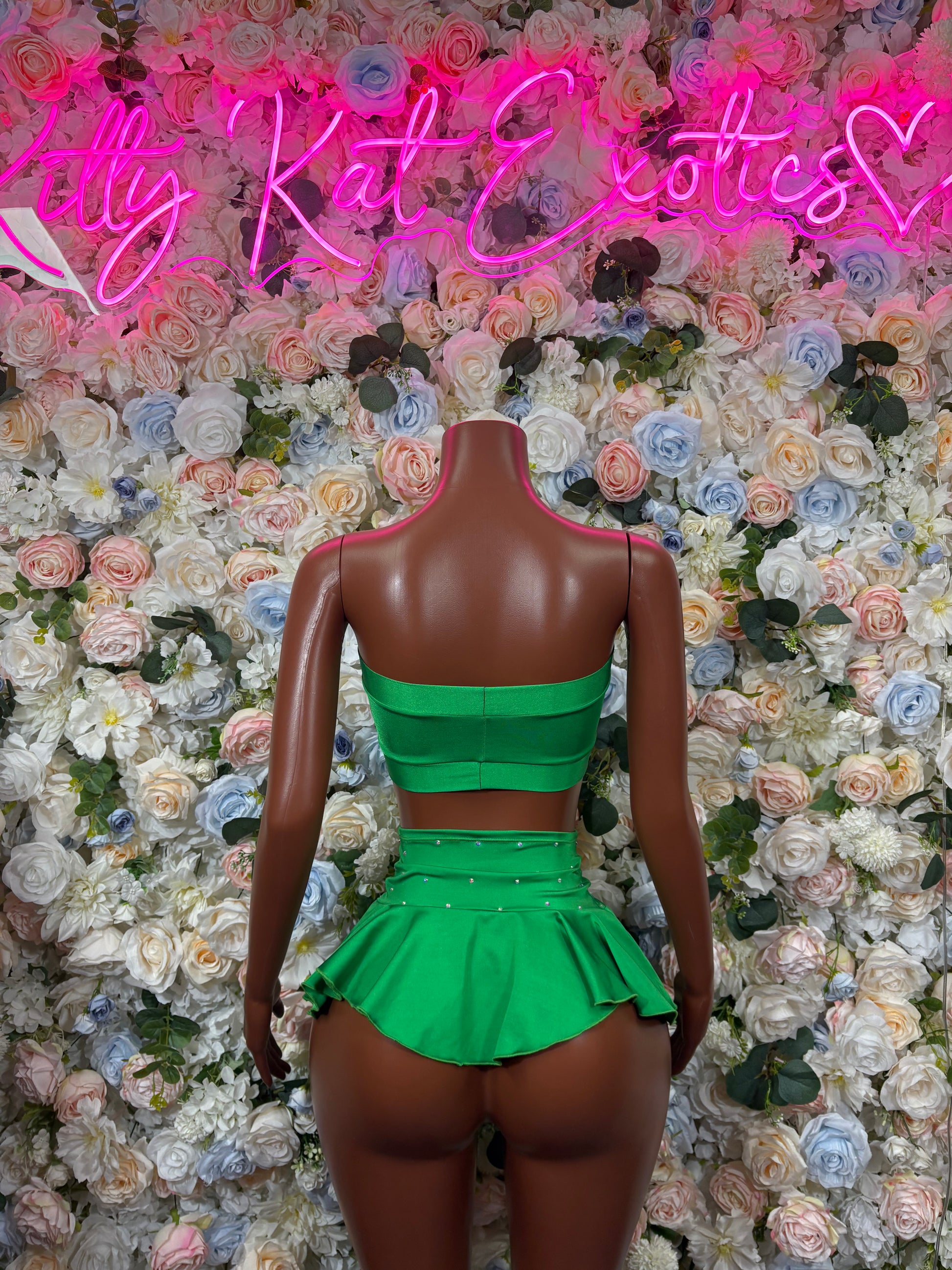 Green two-piece skirt set with bandeau top and ruffled mini skirt, back view