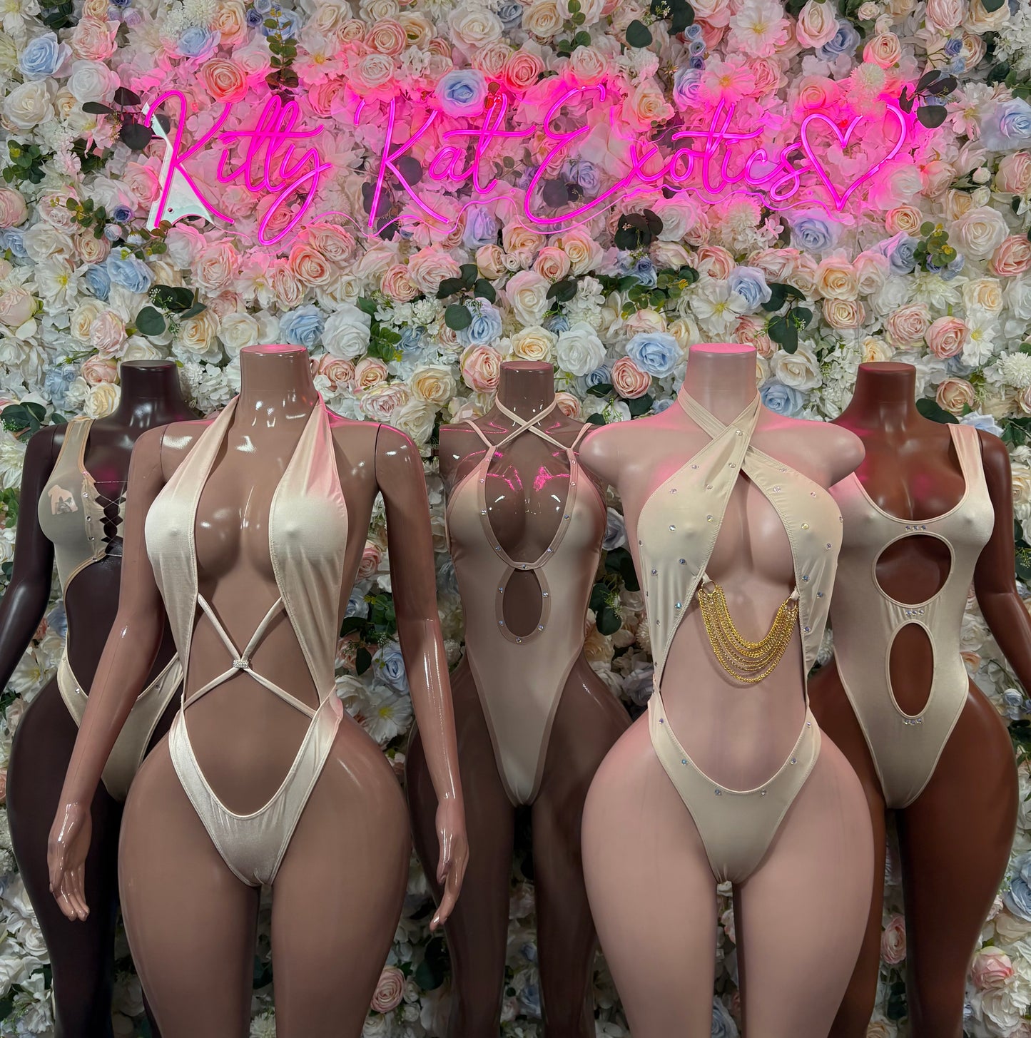 Set of nude one-piece bodysuits with cross straps and high-cut legs on mannequins
