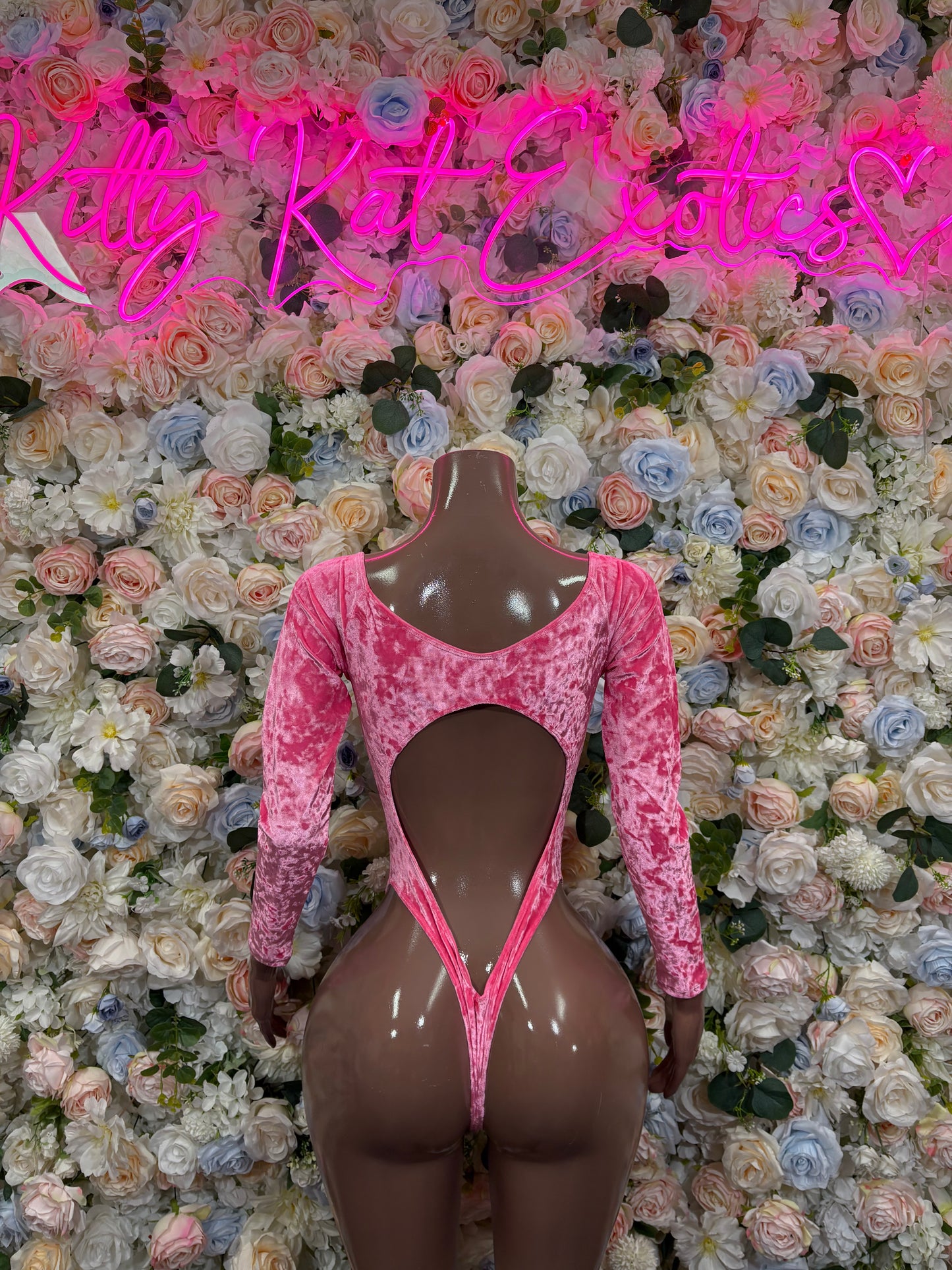 Pink velvet one-piece dancewear with long sleeves and deep front cutout panels