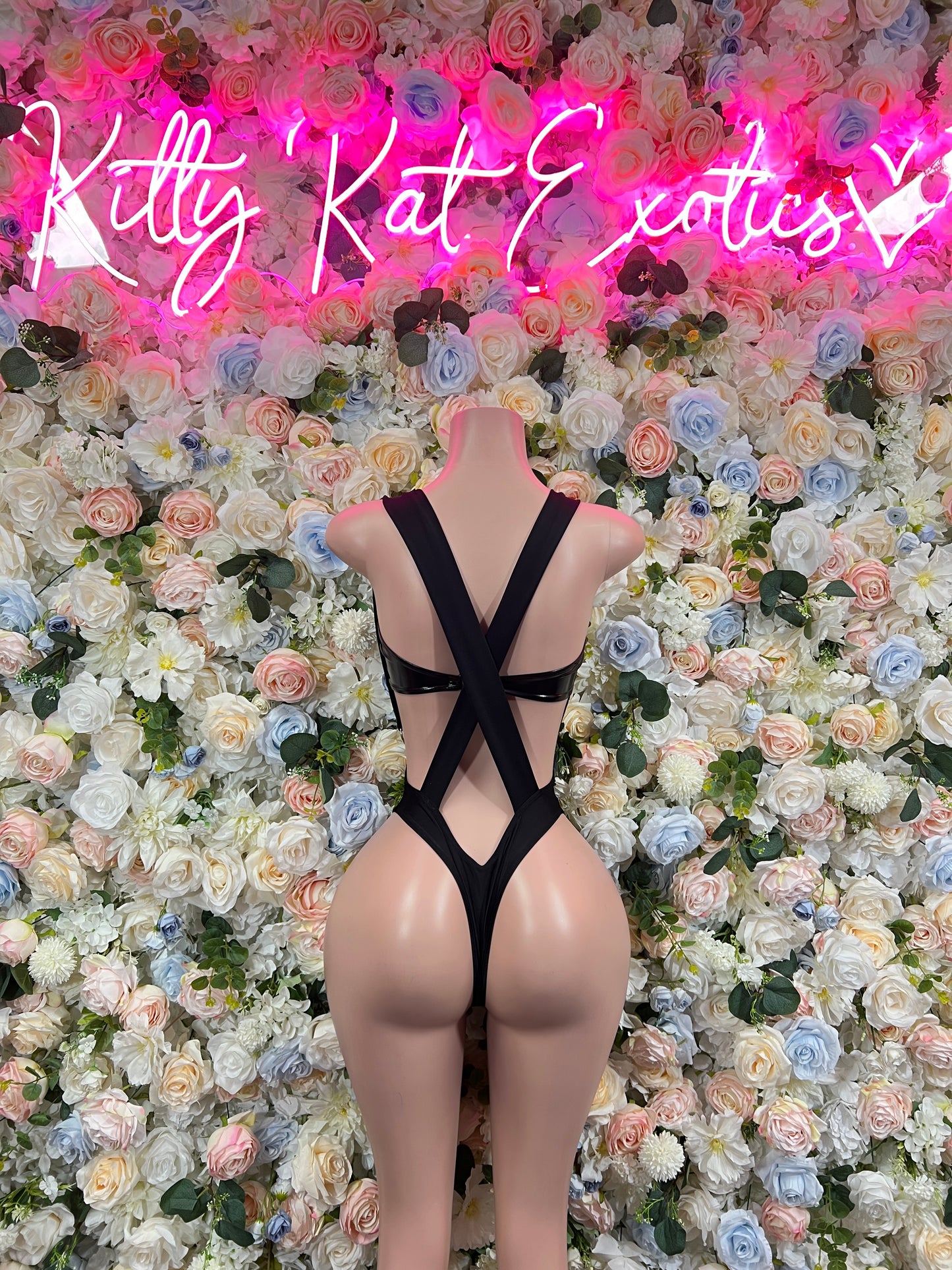 Black one-piece bodysuit with open-back crisscross straps and low front cutout