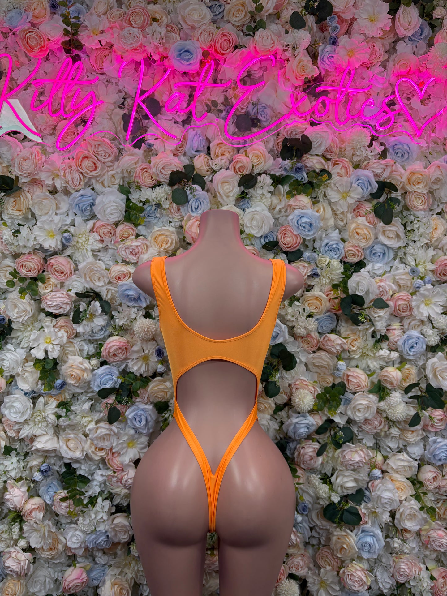 Orange one-piece bodysuit with open back and lace-up back straps
