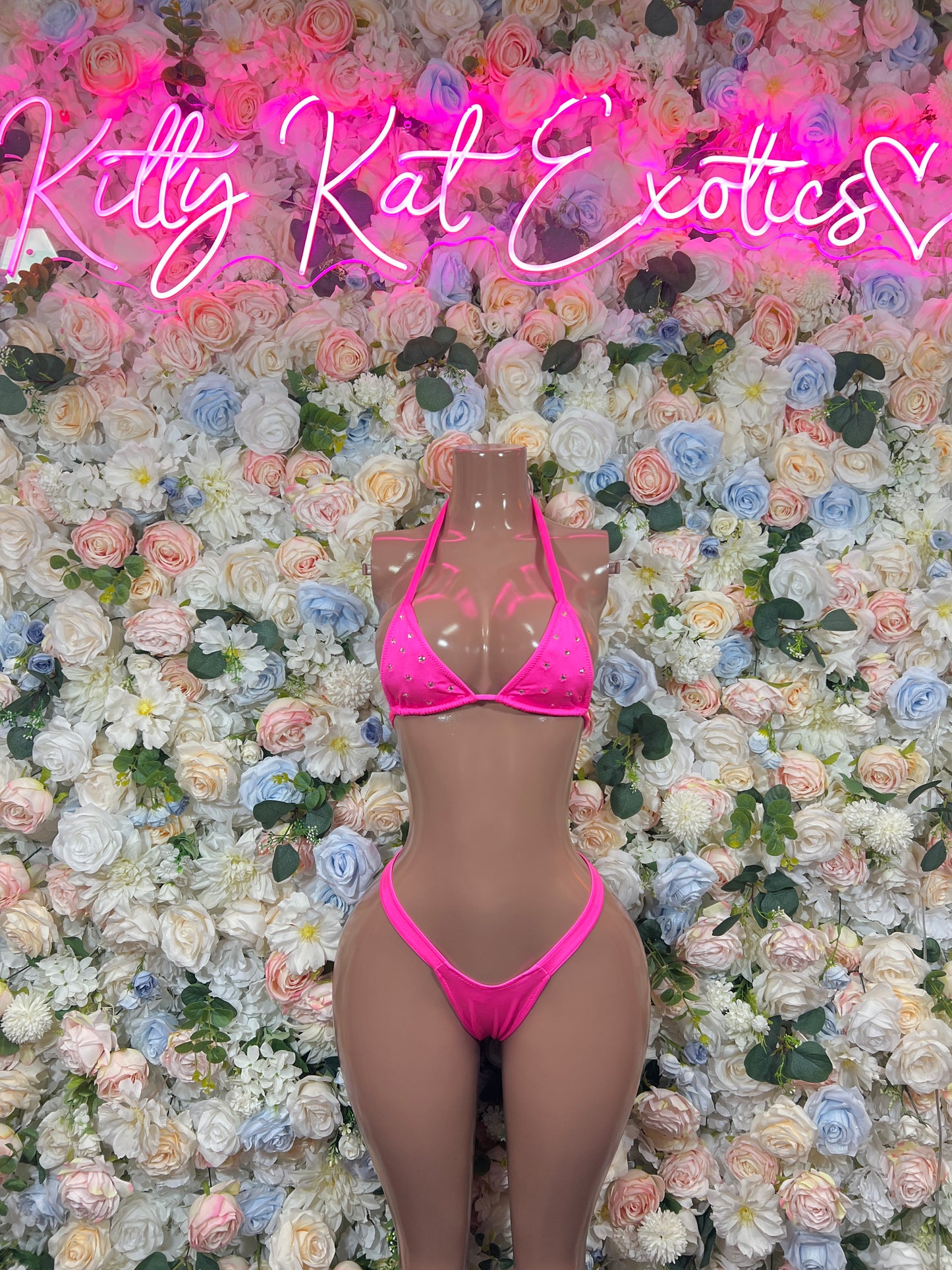 Hot pink triangle bikini top with matching string bottoms on mannequin, front view