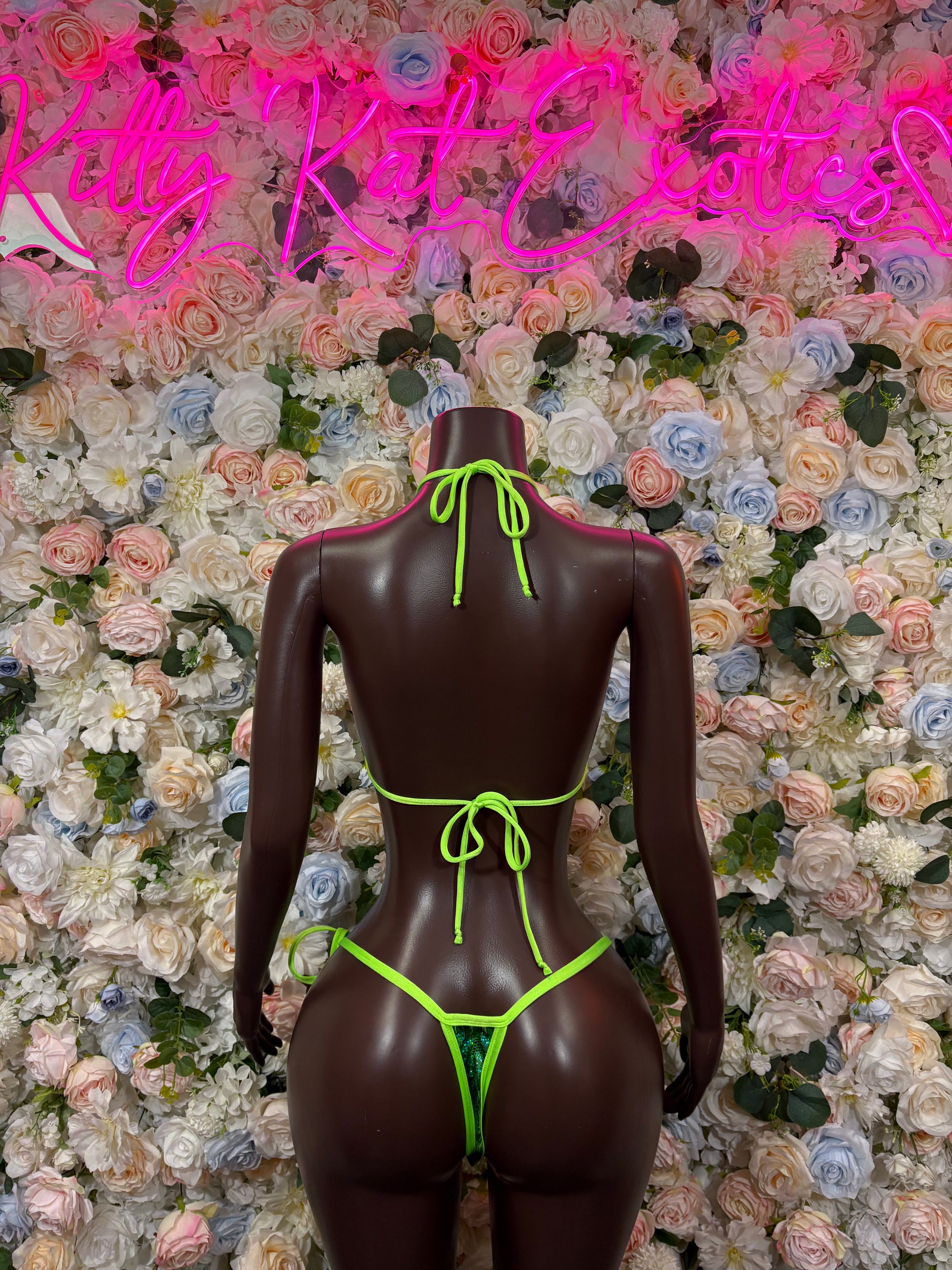 Green metallic triangle bikini with neon green string ties, back view.