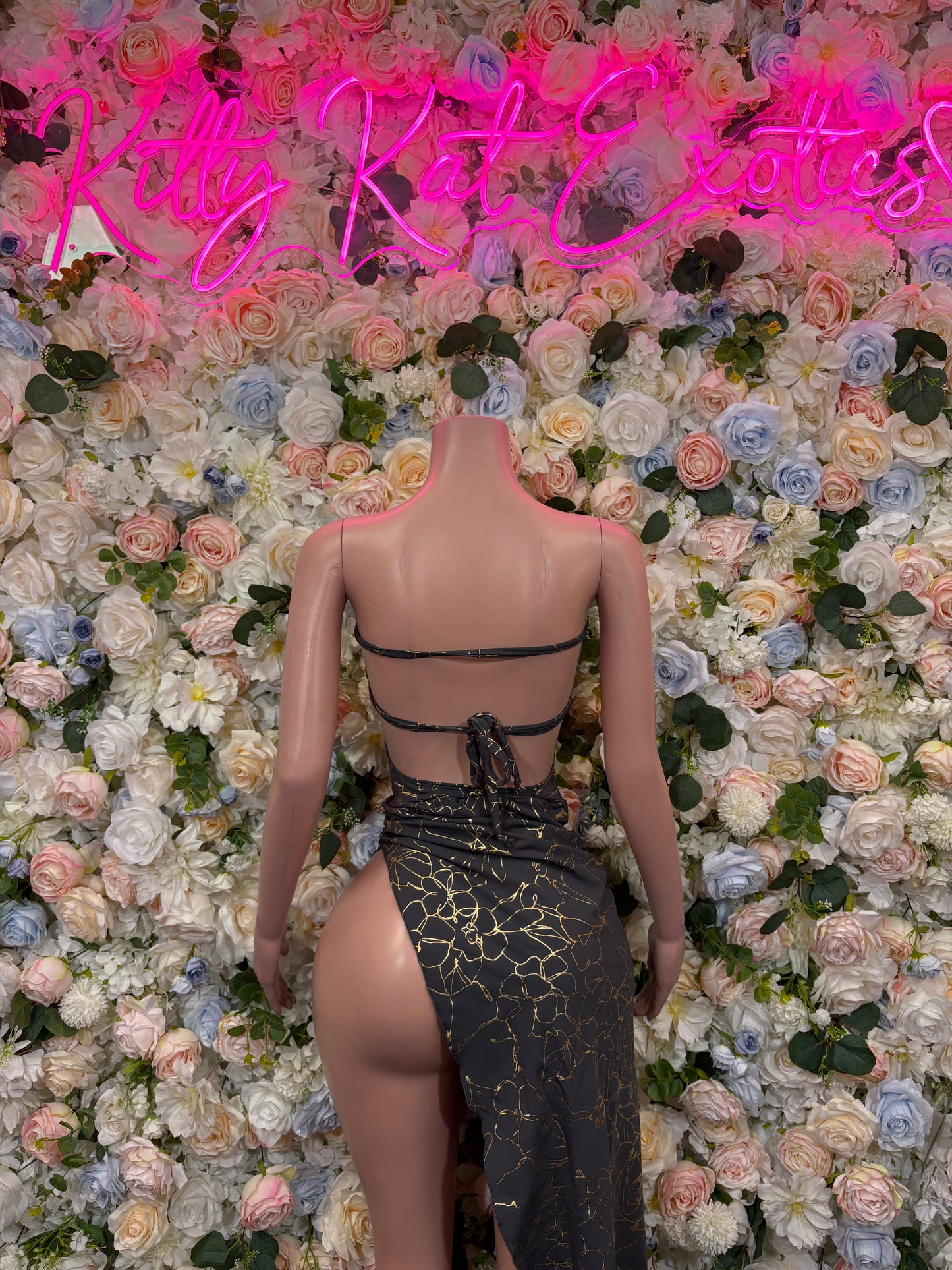 Backless black and gold patterned gown with spaghetti straps and leg slit
